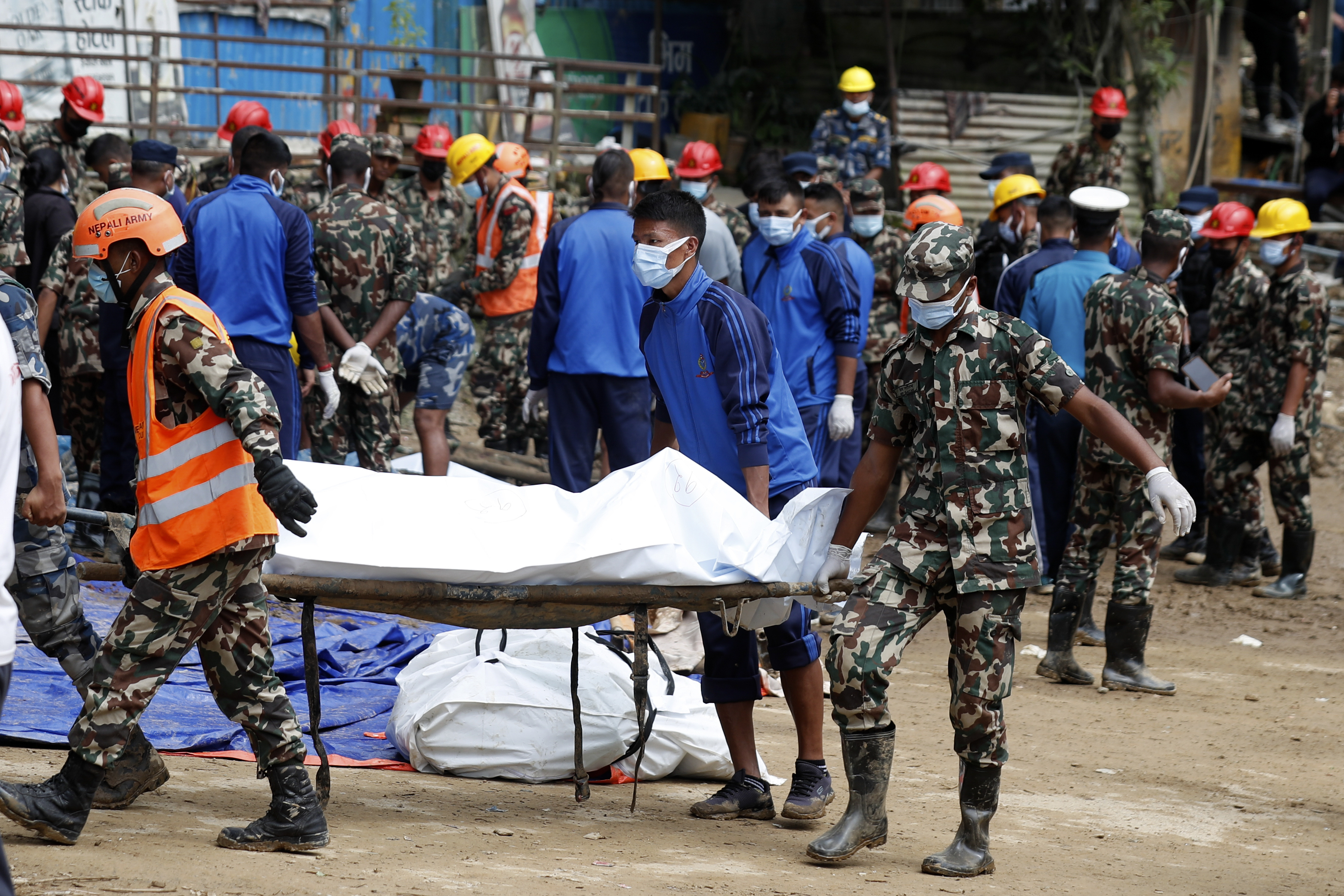 Rescue personnel transport the dead body of a victim who was trapped under a landslide caused by heavy rains in Kathmandu, Nepal, Sunday, Sept. 29, 2024. (AP Photo/Sujan Gurung)