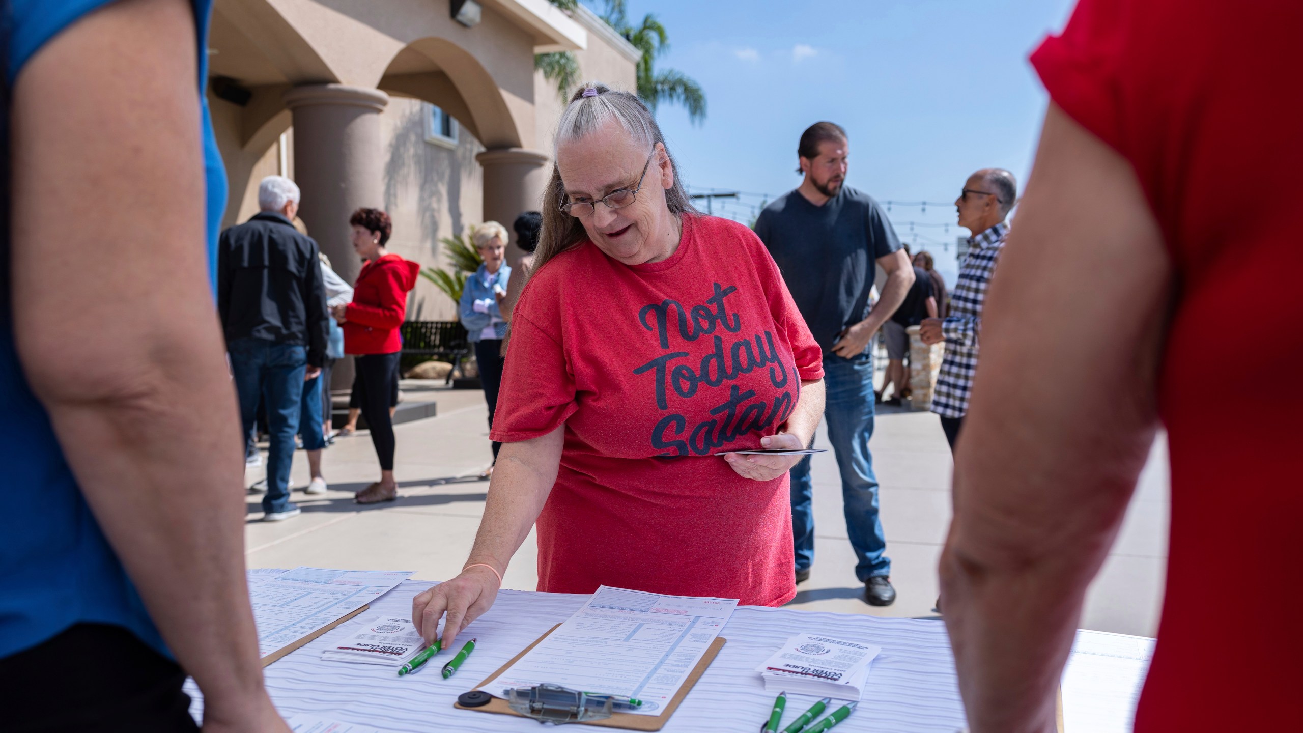 Janet Berkeley stops by a voter registration desk during a Comeback California Tour event at Revival Fellowship, Saturday, Sept. 21, 2024, in Menifee, Calif. (AP Photo/Zoë Meyers)