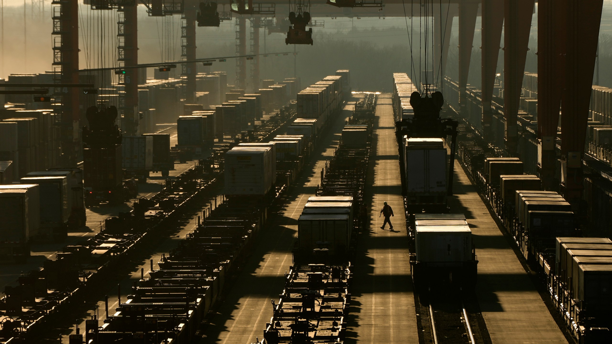 FILE - A worker walks among shipping containers in a loading area at a BNSF intermodal terminal on Jan. 3, 2024, in Edgerton, Kan. (AP Photo/Charlie Riedel, File)