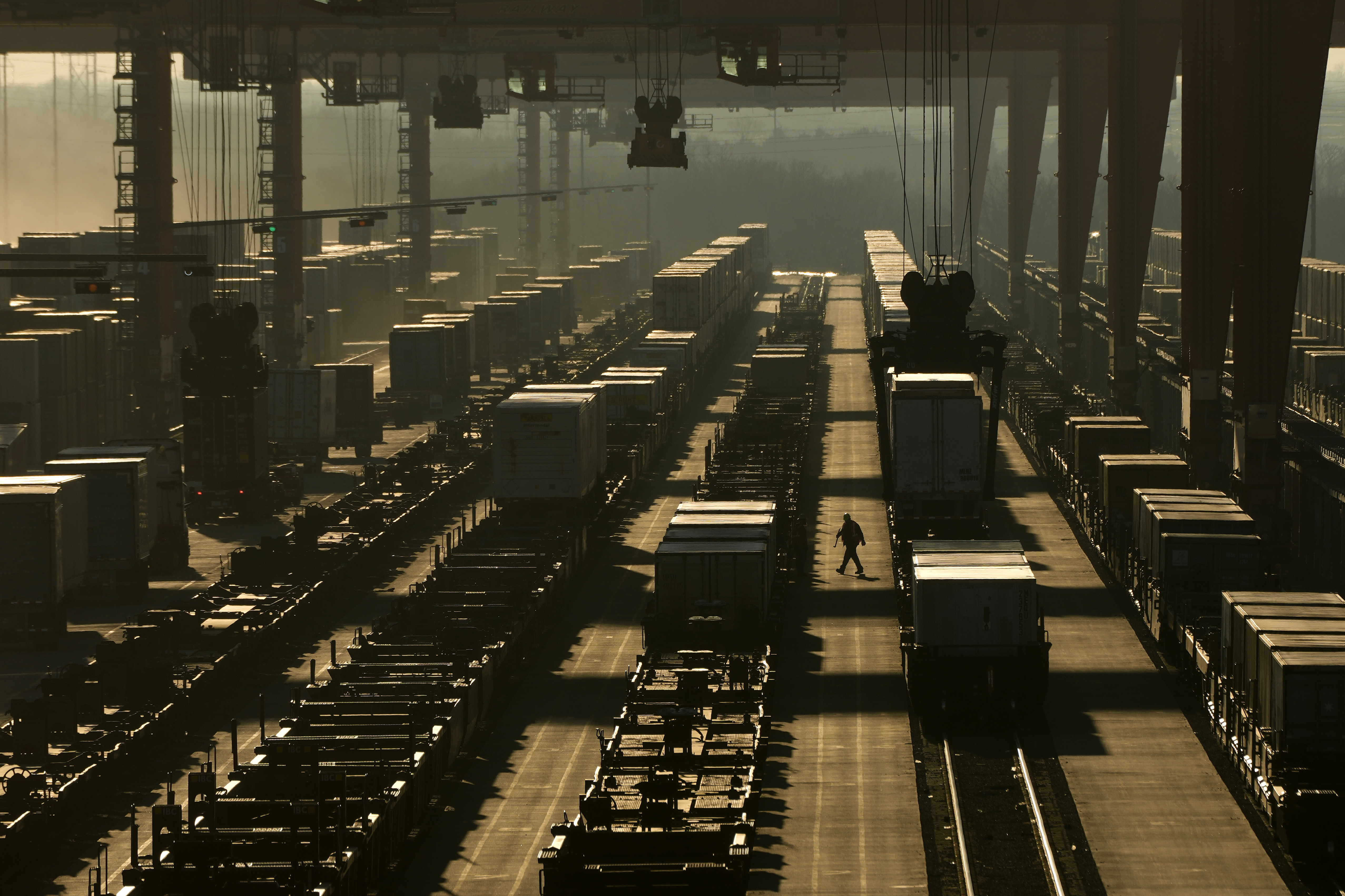 FILE - A worker walks among shipping containers in a loading area at a BNSF intermodal terminal on Jan. 3, 2024, in Edgerton, Kan. (AP Photo/Charlie Riedel, File)