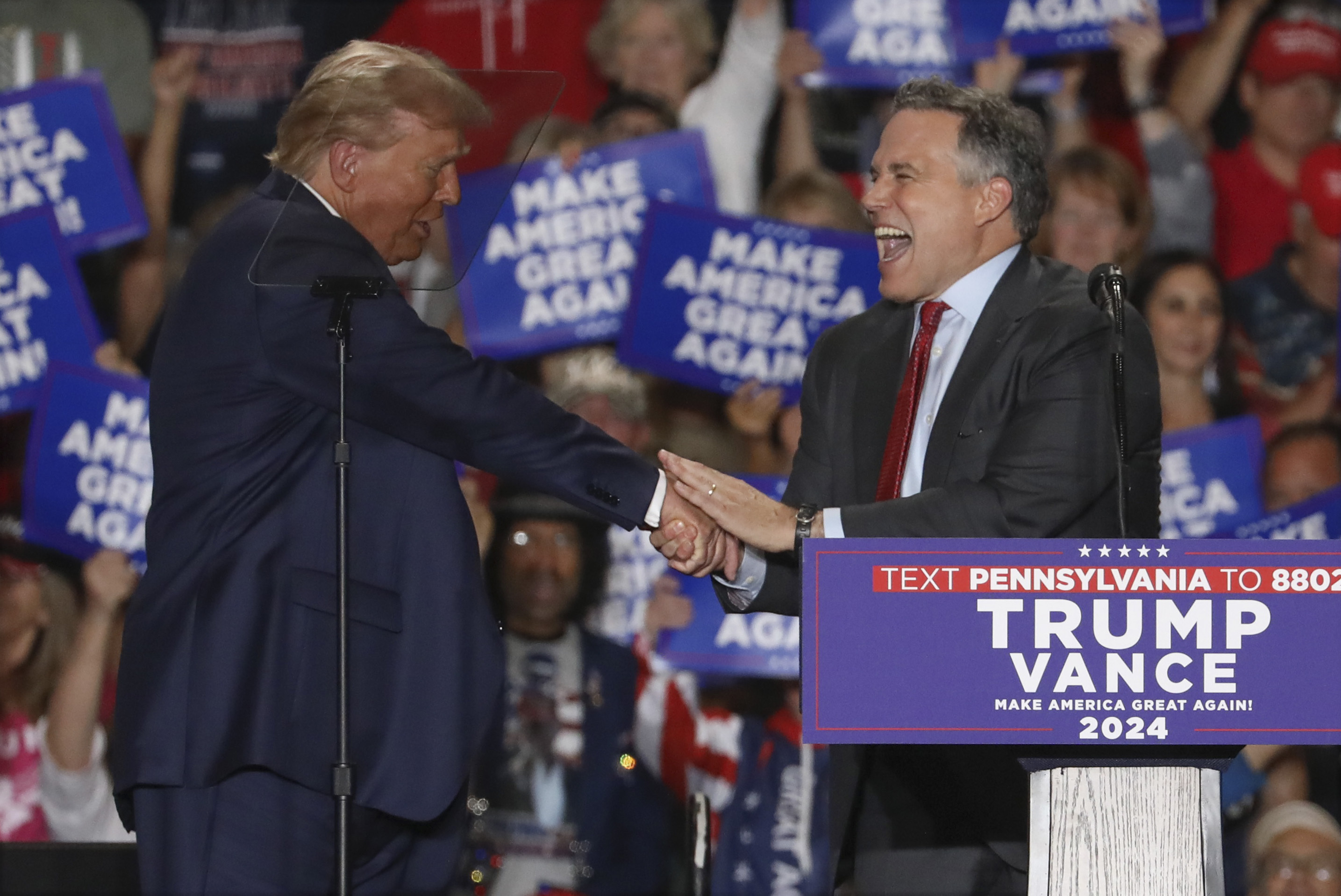 Republican presidential nominee former President Donald Trump shakes hands with Pennsylvania Senate candidate Dave McCormick at a campaign rally at Bayfront Convention Center in Erie, Pa., Sunday, Sept. 29, 2024. (AP Photo/Rebecca Droke)