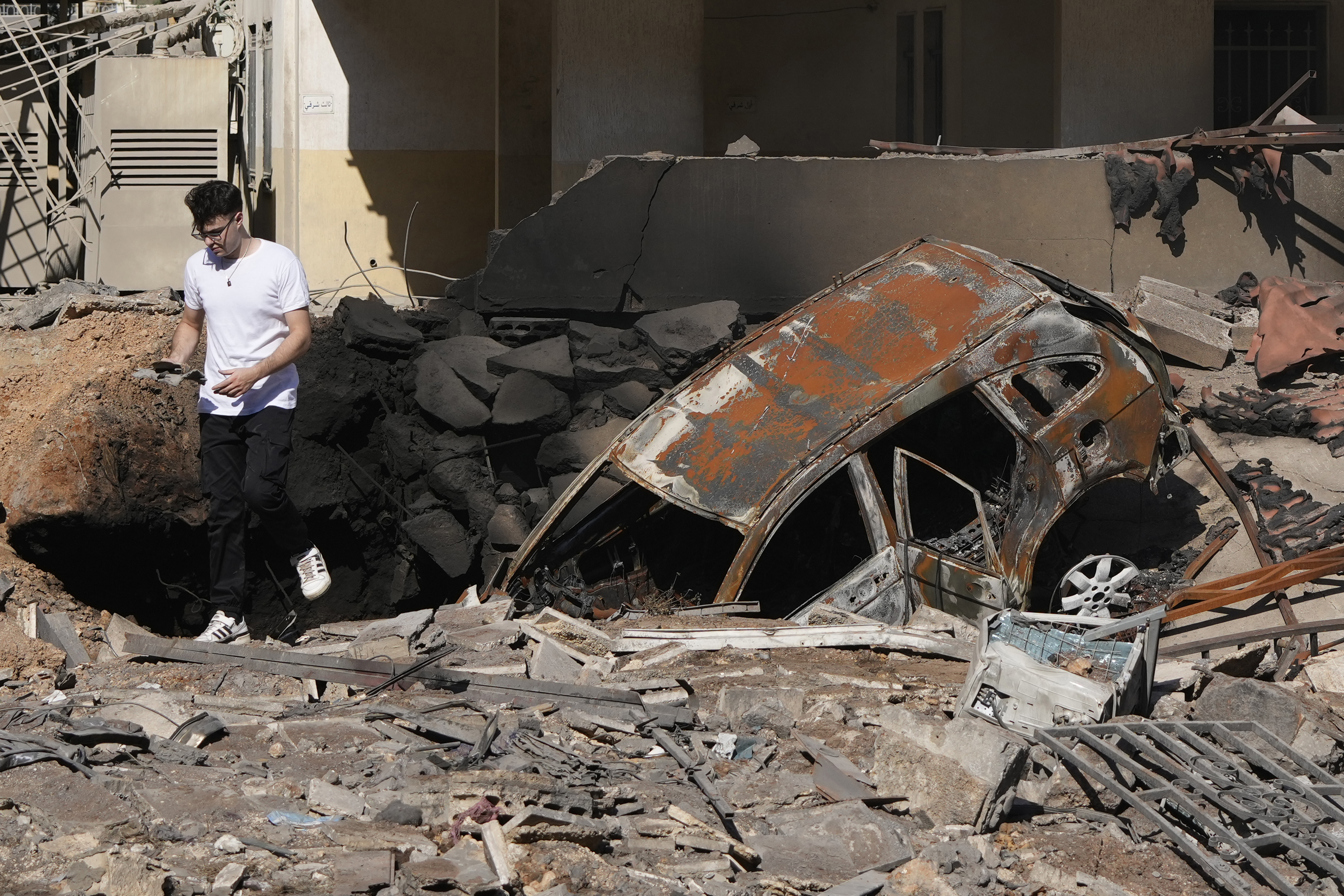 A man walks on rubble at the site of an Israeli airstrike in Beirut's southern suburbs, Sunday, Sept. 29, 2024. (AP Photo/Hassan Ammar)