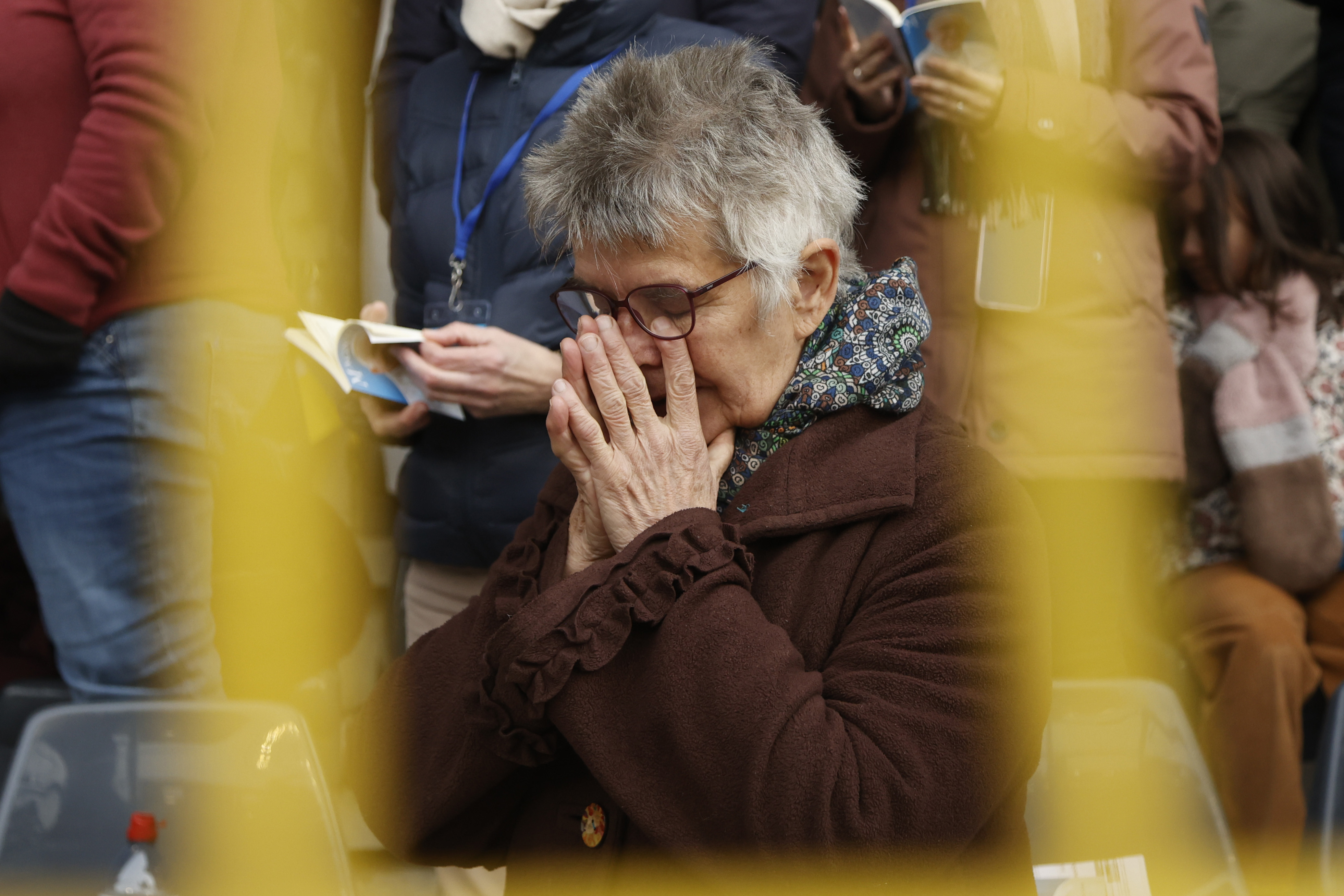 A faithful prays as Pope Francis presides the holy mass , at the King Baudouin stadium in Brussels, Belgium, Sunday, Sept. 29, 2024. (AP Photo/Omar Havana)