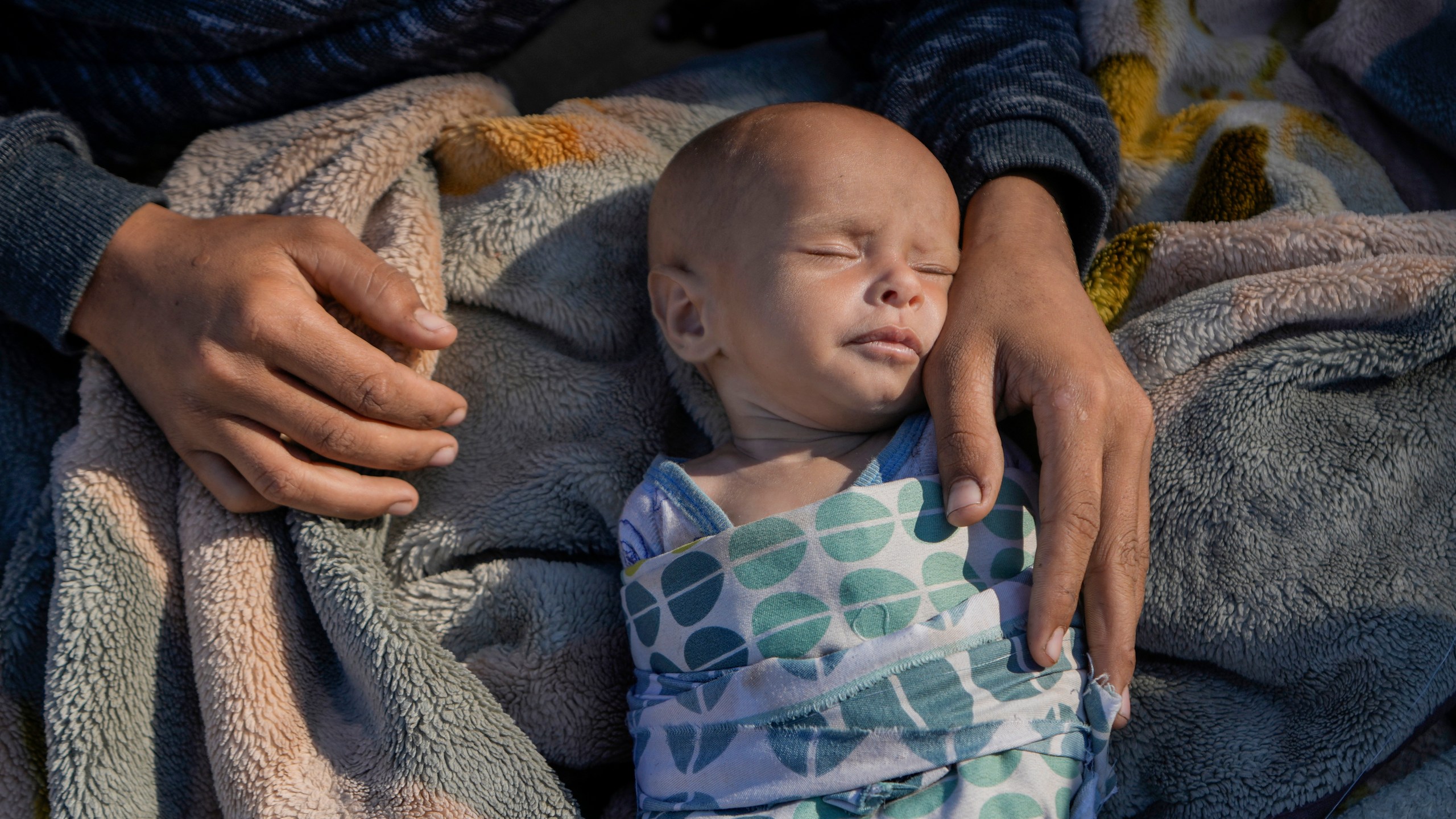 A woman cares for her newborn girl, Fatima, in Beirut's Martyrs' square after fleeing the Israeli airstrikes in the southern suburbs of Dahiyeh, Sunday, Sept. 29, 2024. (AP Photo/Bilal Hussein)