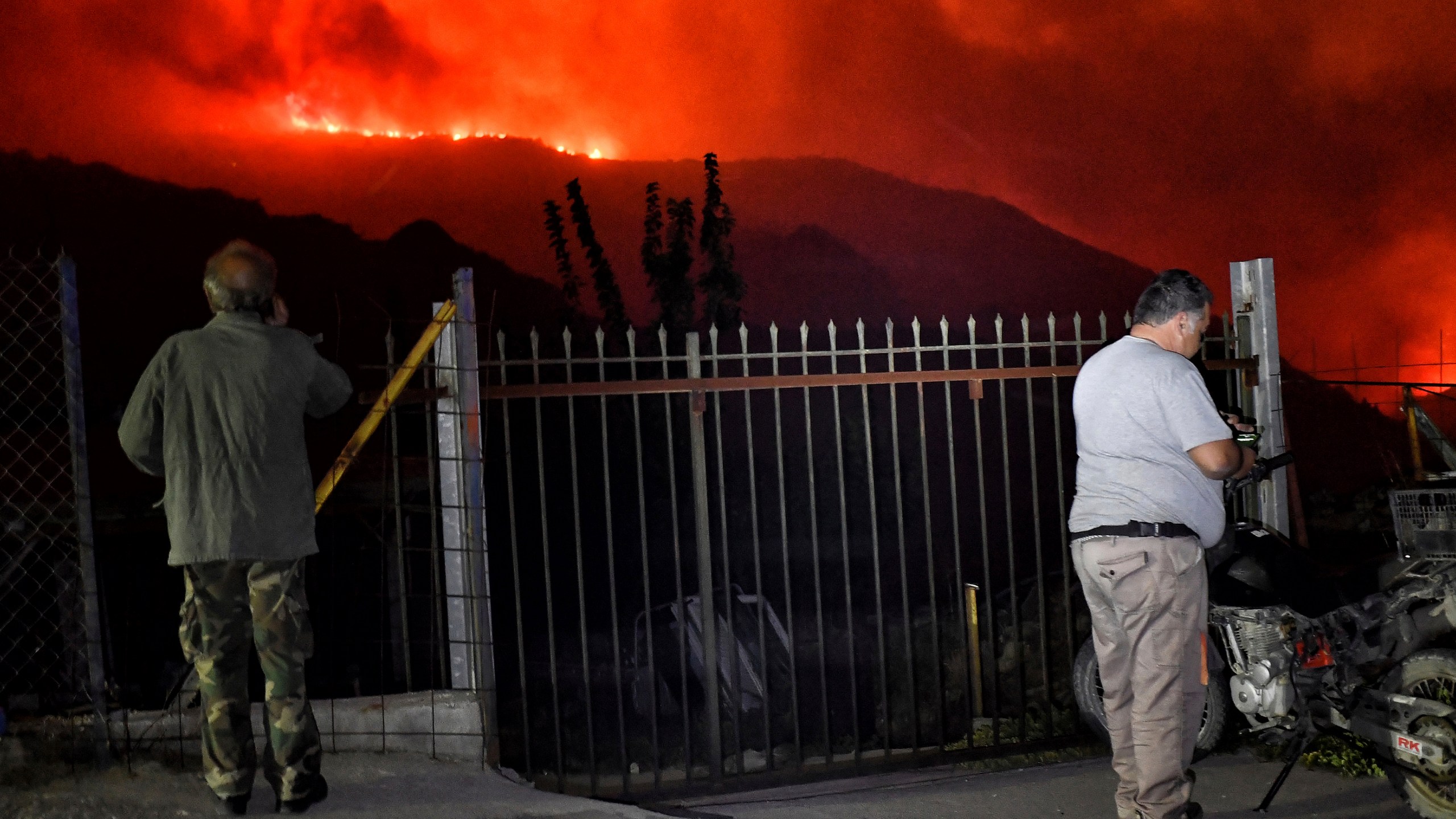 Residents watch a wildfire approaching the village of Kallithea as fanned by strong winds raged uncontrolled despite the attempts of hundreds of firefighters to stop it, some 149 kilometers (93 miles) west of Athens, Greece, in the region of Corinthia, late Sunday, Sept. 29, 2024. (AP Photo)