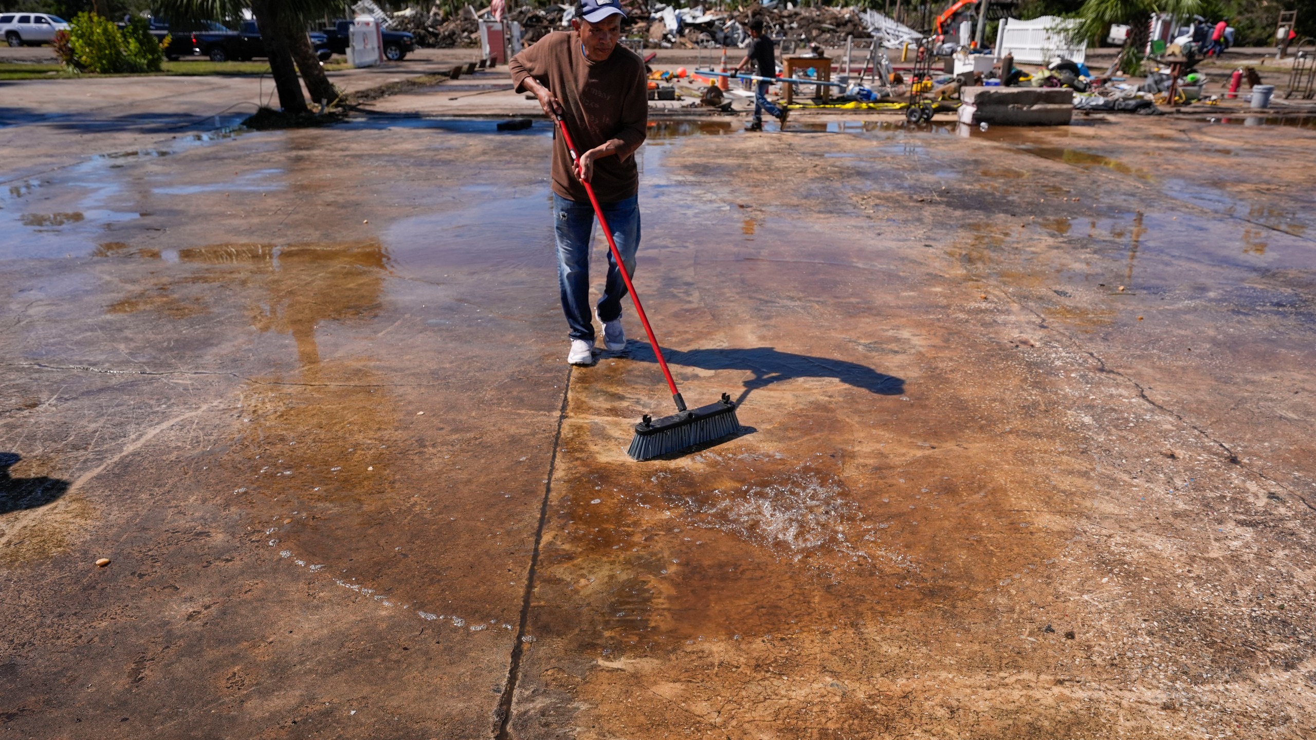 Workers clean up a dock where a boat shed was destroyed in the aftermath of Hurricane Helene, in Jena, Fla., Sunday, Sept. 29, 2024. (AP Photo/Gerald Herbert)