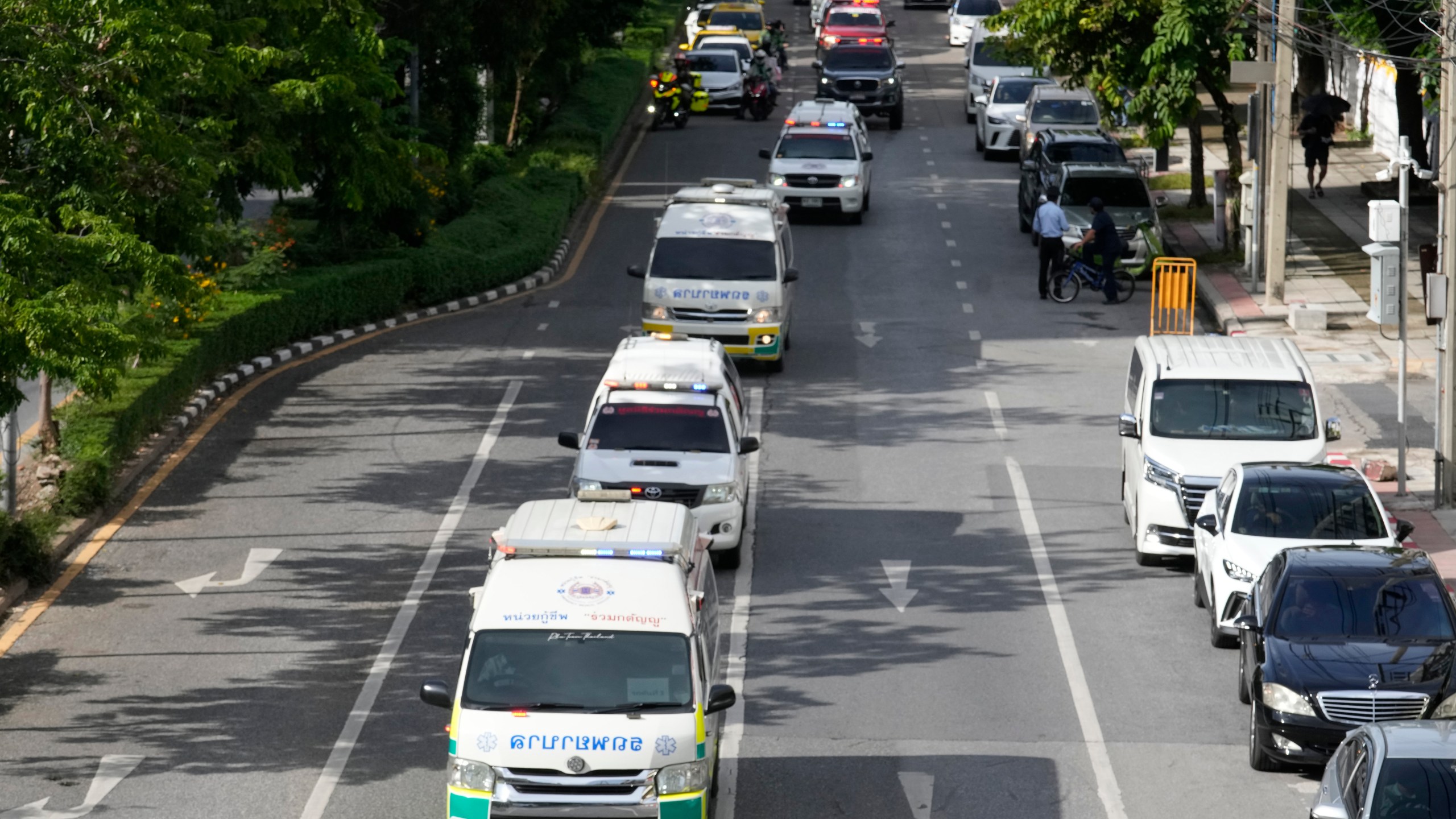 Ambulances carrying bodies of victims of a school bus fire leave from the Police hospital in Bangkok, Thailand, Wednesday, Oct. 2, 2024. (AP Photo/Sakchai Lalit)