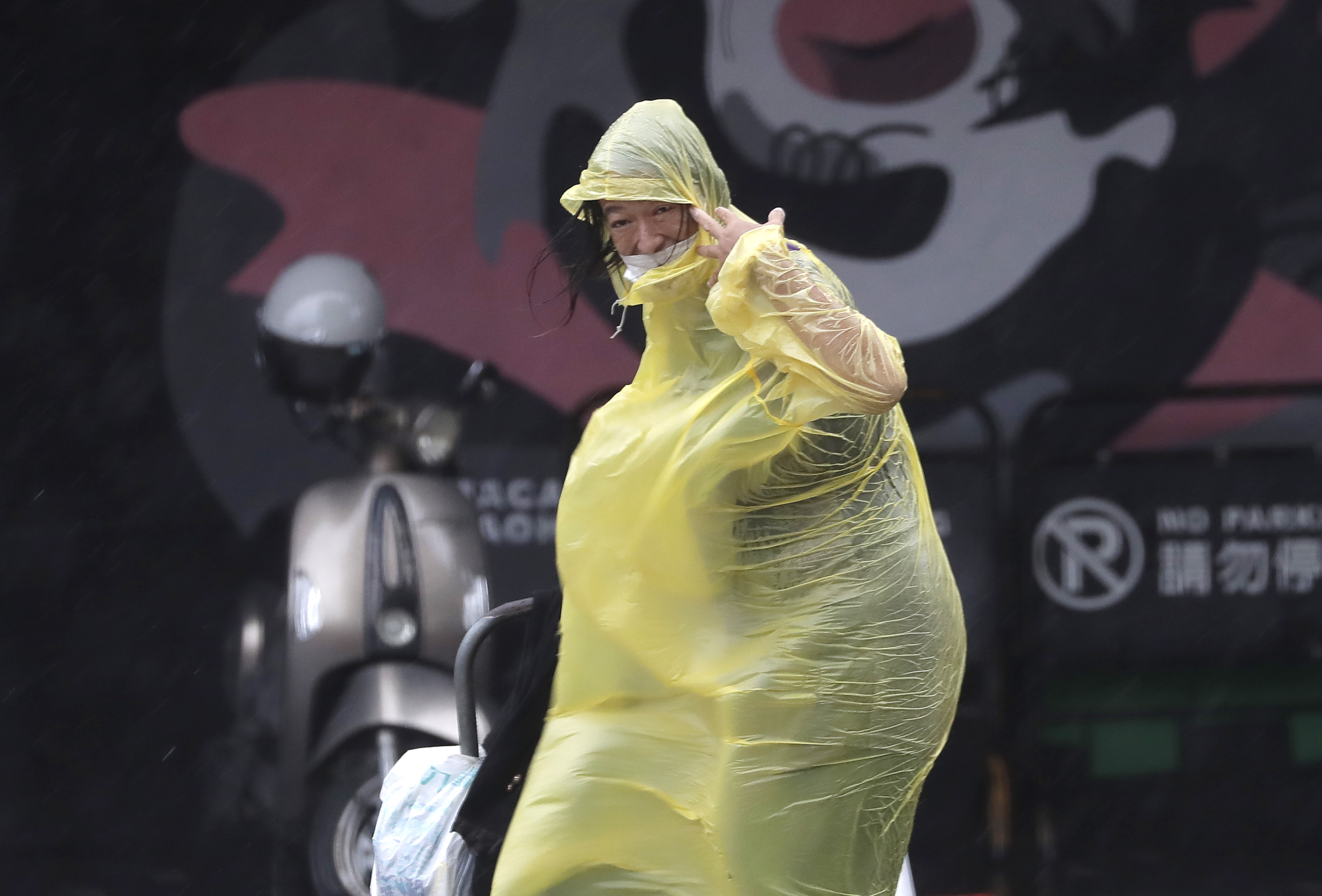 A woman struggles with winds generated by Typhoon Krathon in Kaohsiung, Southern Taiwan, Wednesday, Oct. 2, 2024. (AP Photo/Chiang Ying-ying)