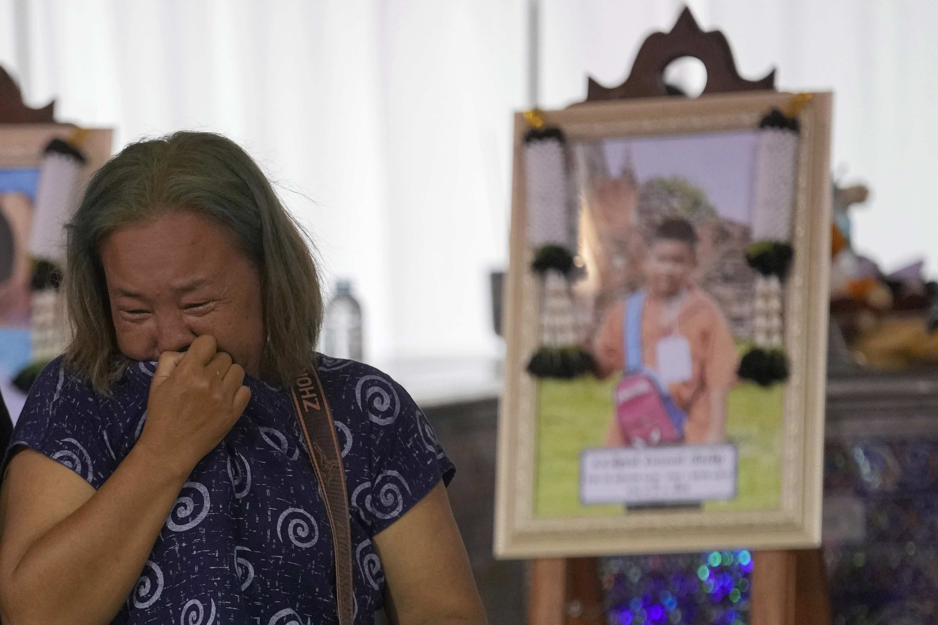 A relative wails near the coffin of a victim of school bus fire at Wat Khao Phraya Sangkharam School, Lan Sak, Uthai Thani province, Thailand, Thursday, Oct. 3, 2024. (AP Photo/Sakchai Lalit)