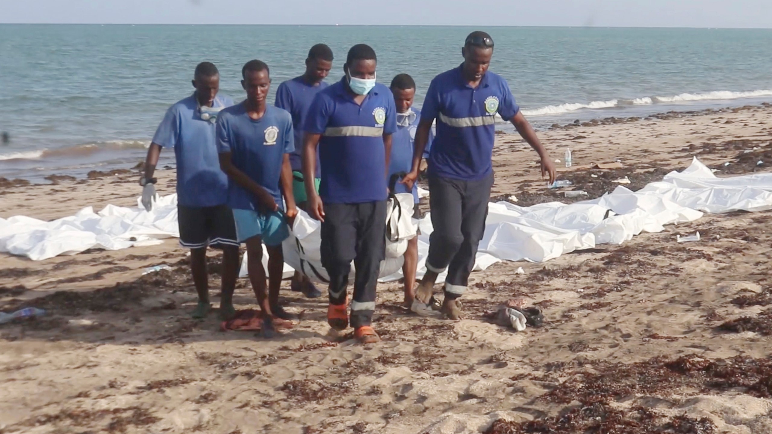 In this image made from video, Djiboutian coast guard workers load bodies of migrants who were washed away on the shore of the Red Sea, off the coast in Djibouti Wednesday, Oct. 2, 2024. (Djiboutian Coast Guard via AP)