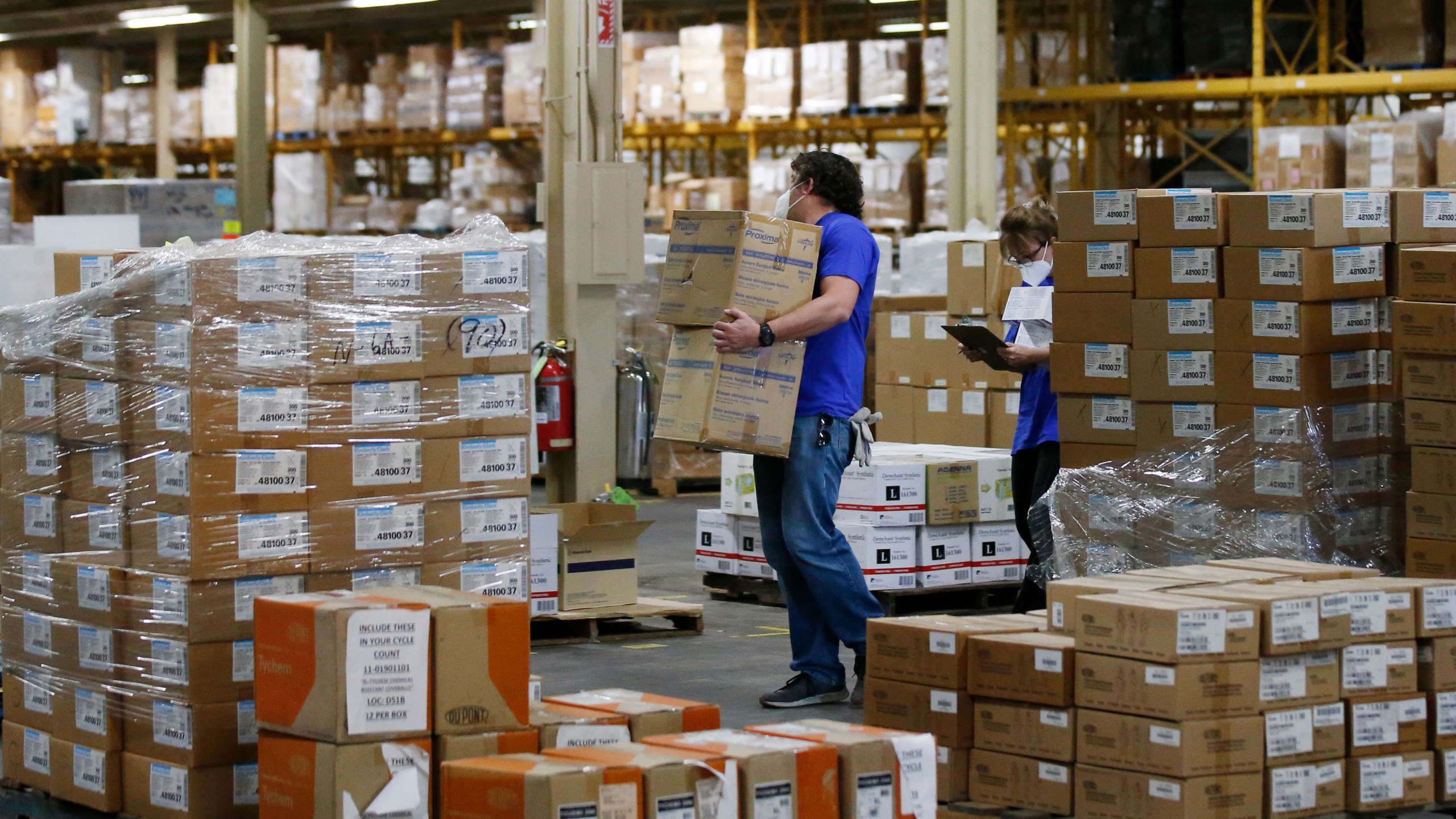 FILE - Workers carry boxes at a Strategic National Stockpile warehouse in Oklahoma City, Okla., April 7, 2020. (AP Photo/Sue Ogrocki, File)