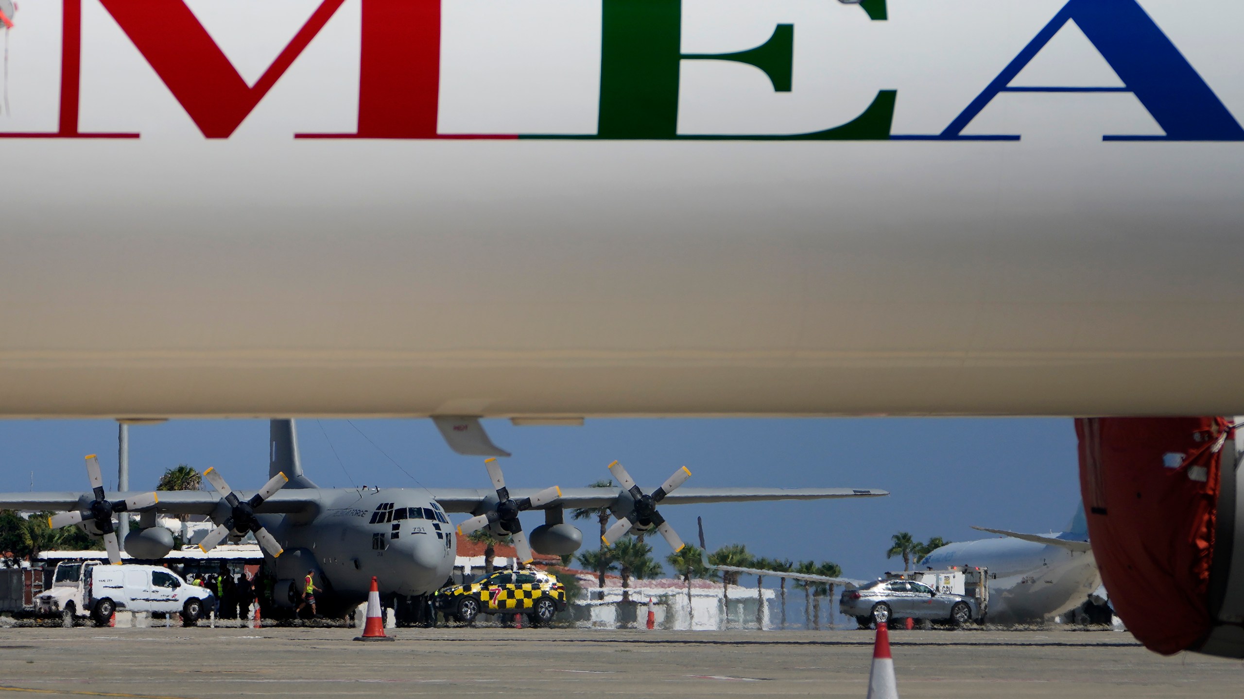 A Greek military transport aircraft carrying Greek and Cypriot citizens evacuated from Lebanon, is seen behind an MEA airlines, after it landed at Larnaca airport, Cyprus, on Thursday, Oct. 3, 2024. (AP Photo/Petros Karadjias)