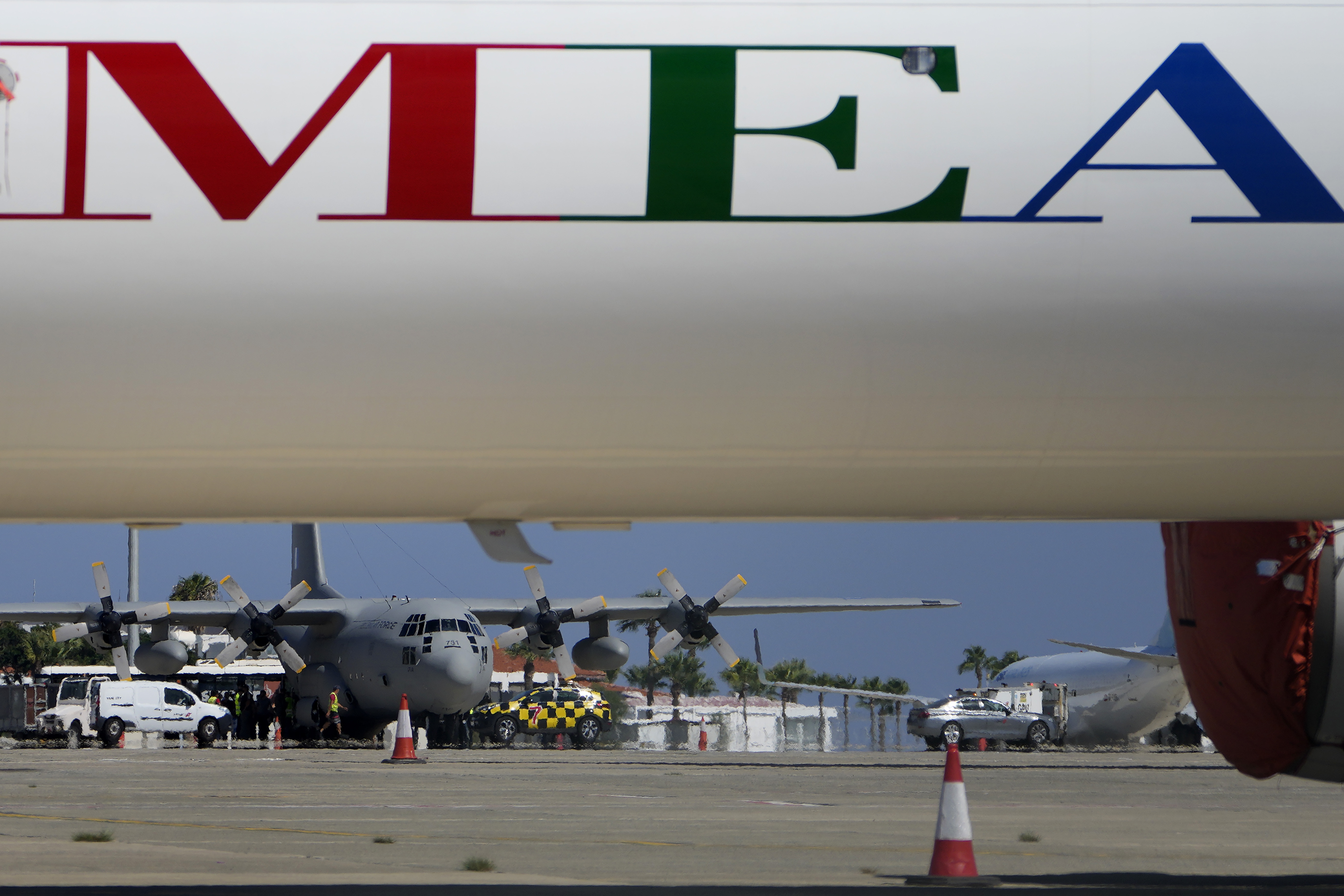 A Greek military transport aircraft carrying Greek and Cypriot citizens evacuated from Lebanon, is seen behind an MEA airlines, after it landed at Larnaca airport, Cyprus, on Thursday, Oct. 3, 2024. (AP Photo/Petros Karadjias)