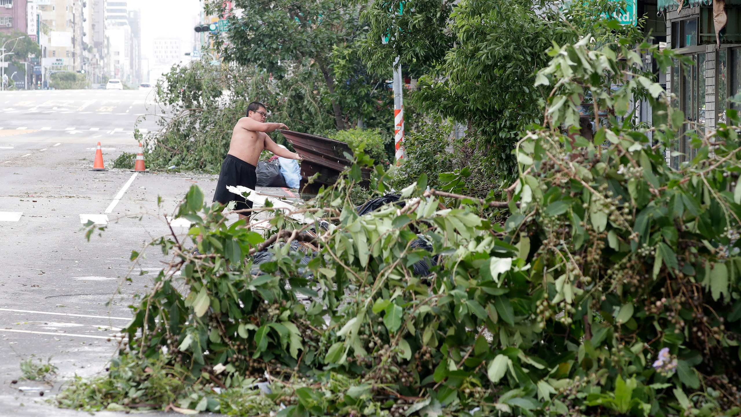 A man clears debris in the aftermath of Typhoon Krathon in Kaohsiung, southern Taiwan, Friday, Oct. 4, 2024. (AP Photo/Chiang Ying-ying)