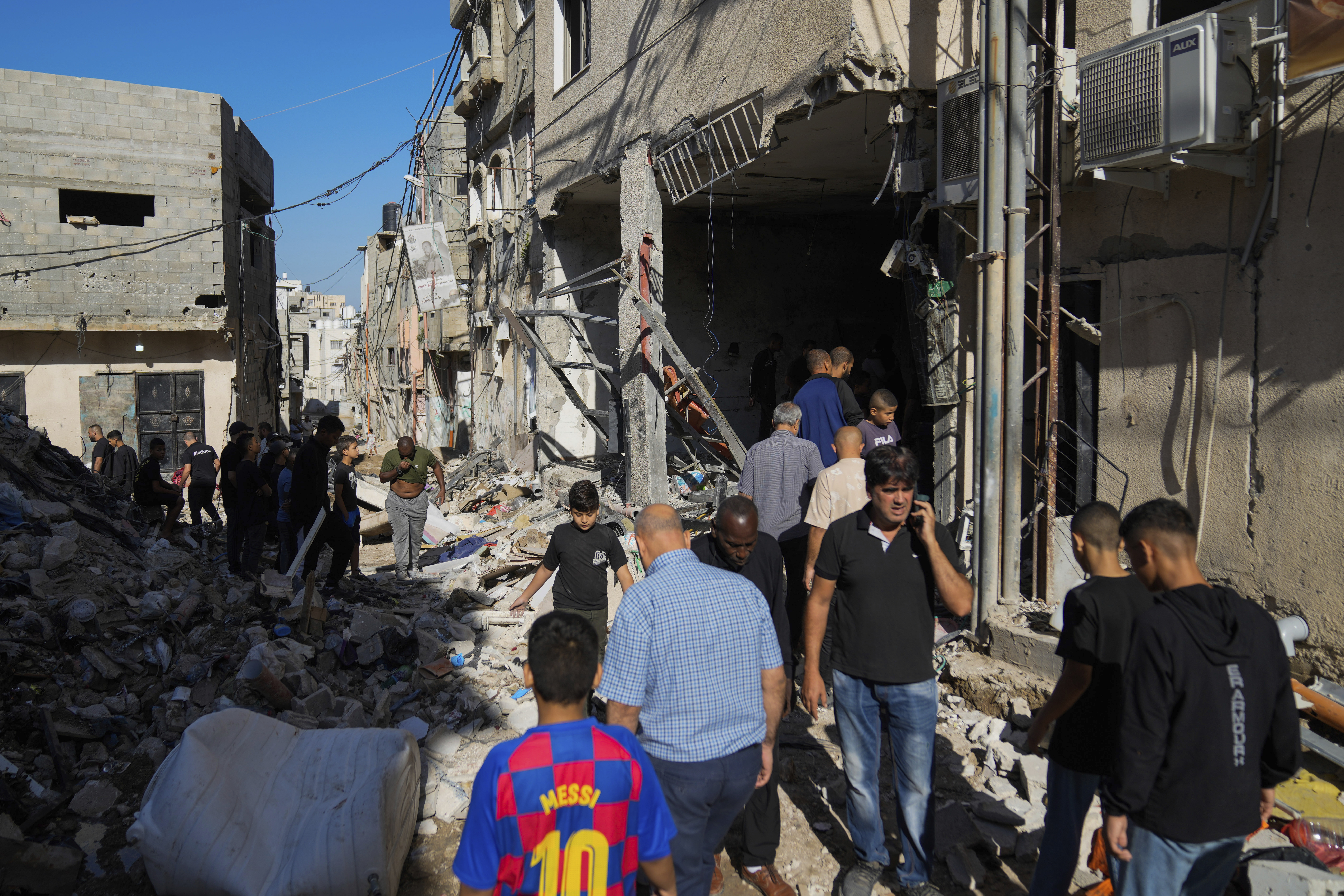 Palestinians examine the damage following an Israeli airstrike in the West Bank city of Tulkarem, which Palestinian health officials say killed 18 people and the Israeli military says took out a Hamas leader, on Friday, Oct. 4, 2024. (AP Photo/Nasser Nasser)