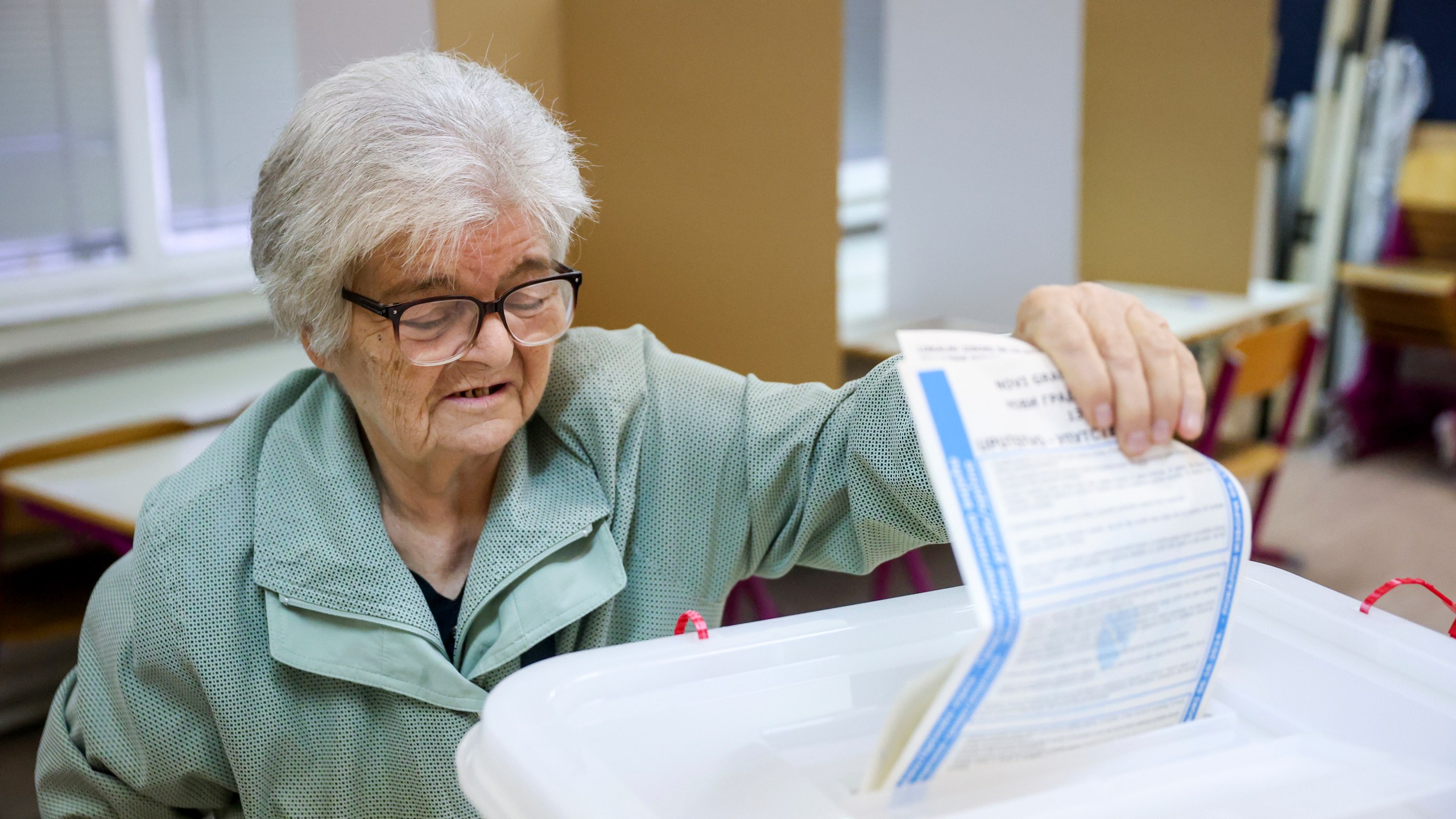 A woman casts her vote for a municipal election at a polling station in Sarajevo, Bosnia, Sunday, Oct. 6, 2024. (AP Photo/Armin Durgut)