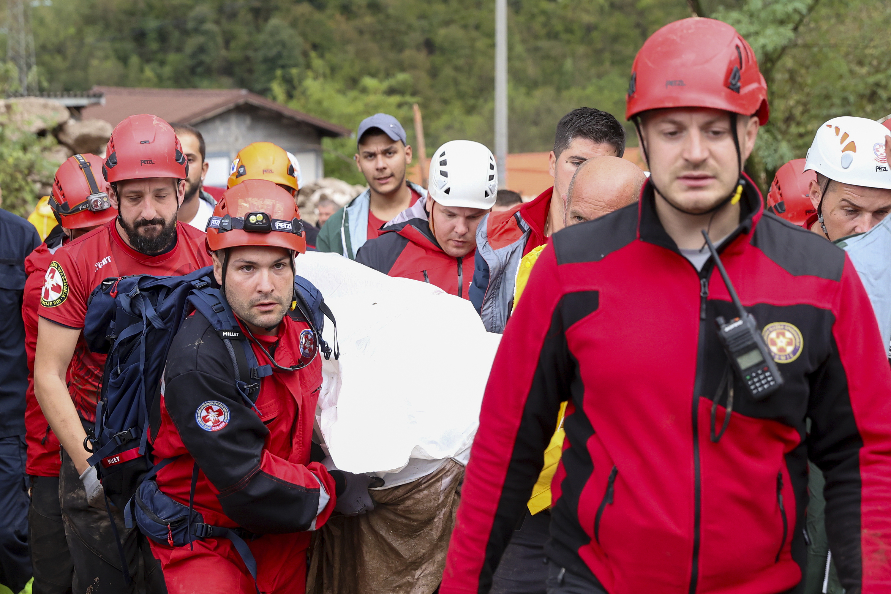 Members of the mountain rescue service carry a body of a person killed by a landslide in the flooded village of Donja Jablanica, Bosnia, Saturday, Oct. 5, 2024. (AP Photo/Armin Durgut)