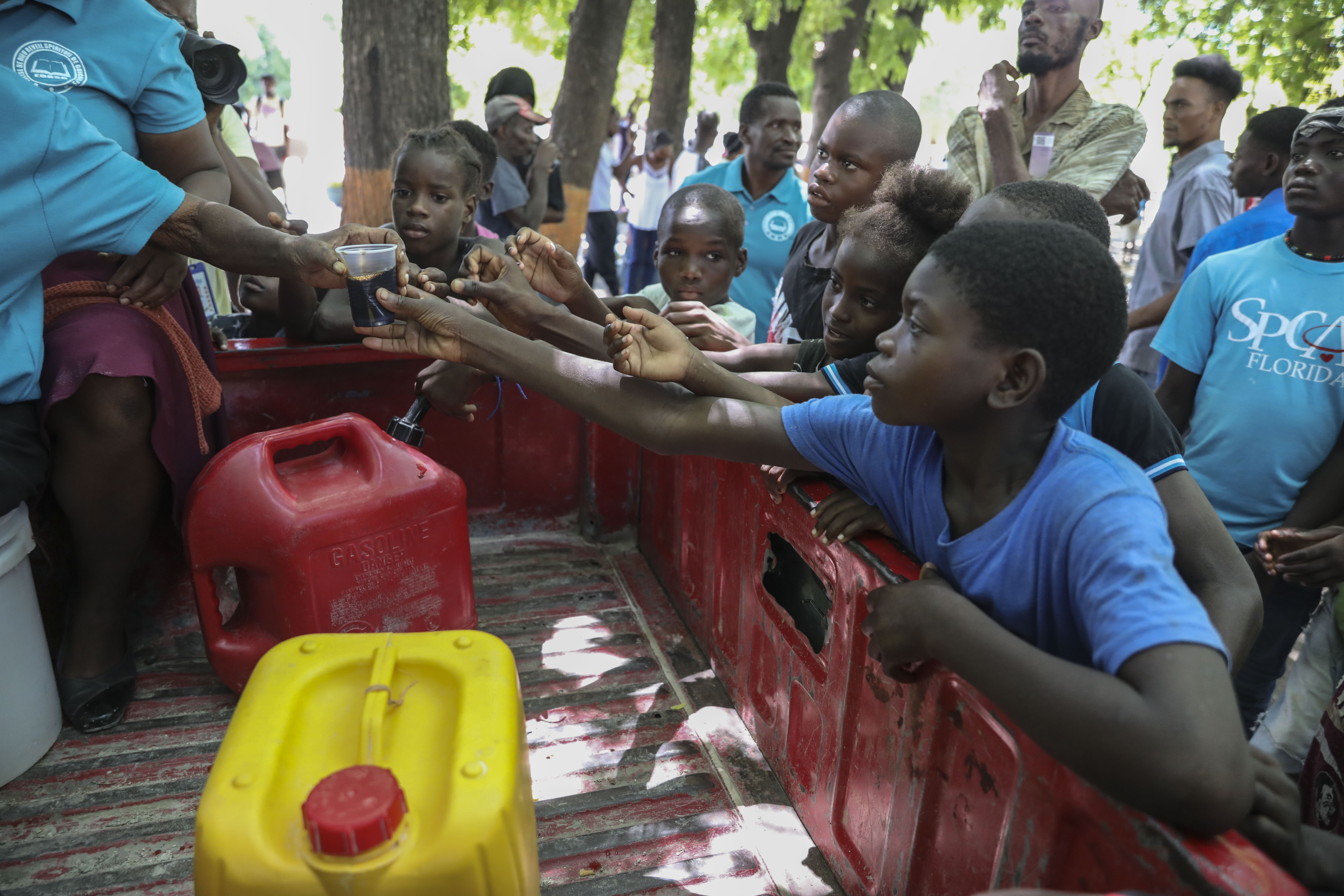 People displaced by armed attacks receive food from a nongovernmental organization in Saint-Marc, Haiti, Sunday, Oct. 6, 2024. (AP Photo/Odelyn Joseph)