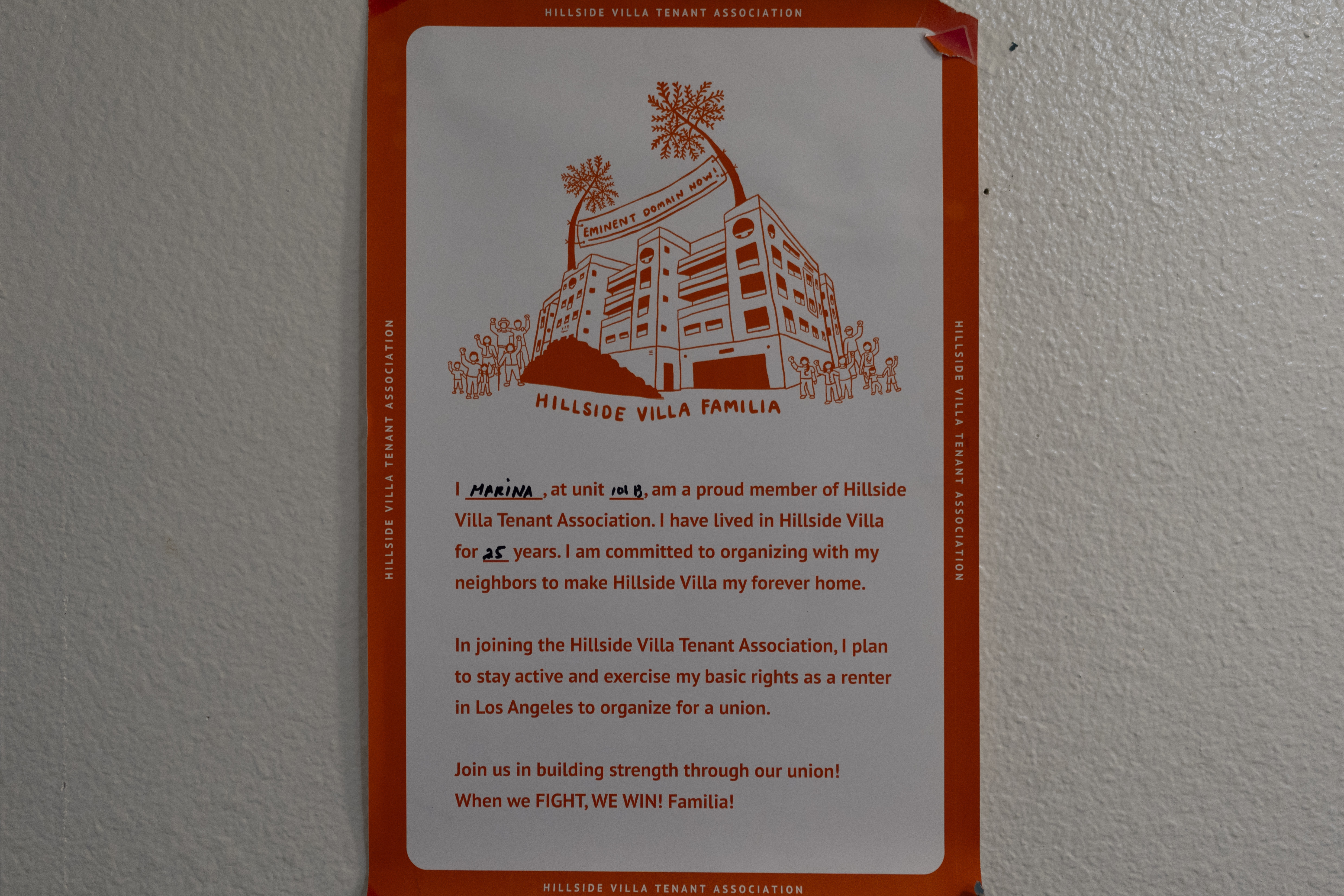 A poster symbolizing solidarity within the tenant community hangs on the wall of Marina Maalouf's apartment in Los Angeles, Tuesday, Oct. 1, 2024. Maalouf, a longtime Hillside Villa apartment complex resident, participated in protests after rents doubled in 2019. (AP Photo/Jae C. Hong)