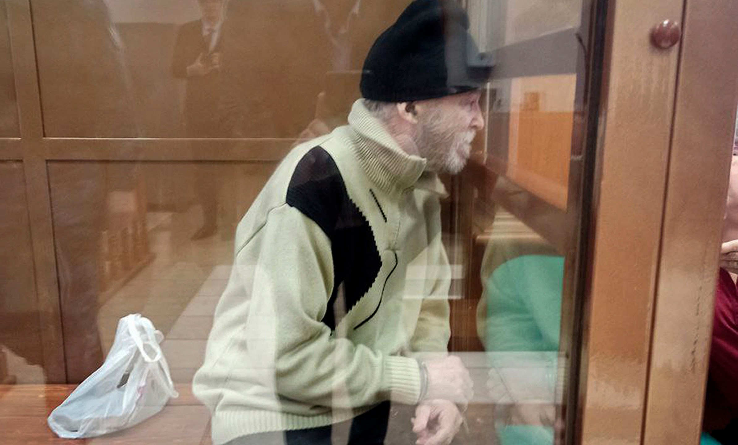 In this photo released by the Moscow City Court Press Service, Stephen Hubbard, a U.S. citizen accused of fighting as a mercenary in Ukraine against Russia sits in a glass cage during a court session in the Moscow City court in Moscow, Russia, Monday, Oct. 7, 2024. (Moscow City Court Press Service via AP)