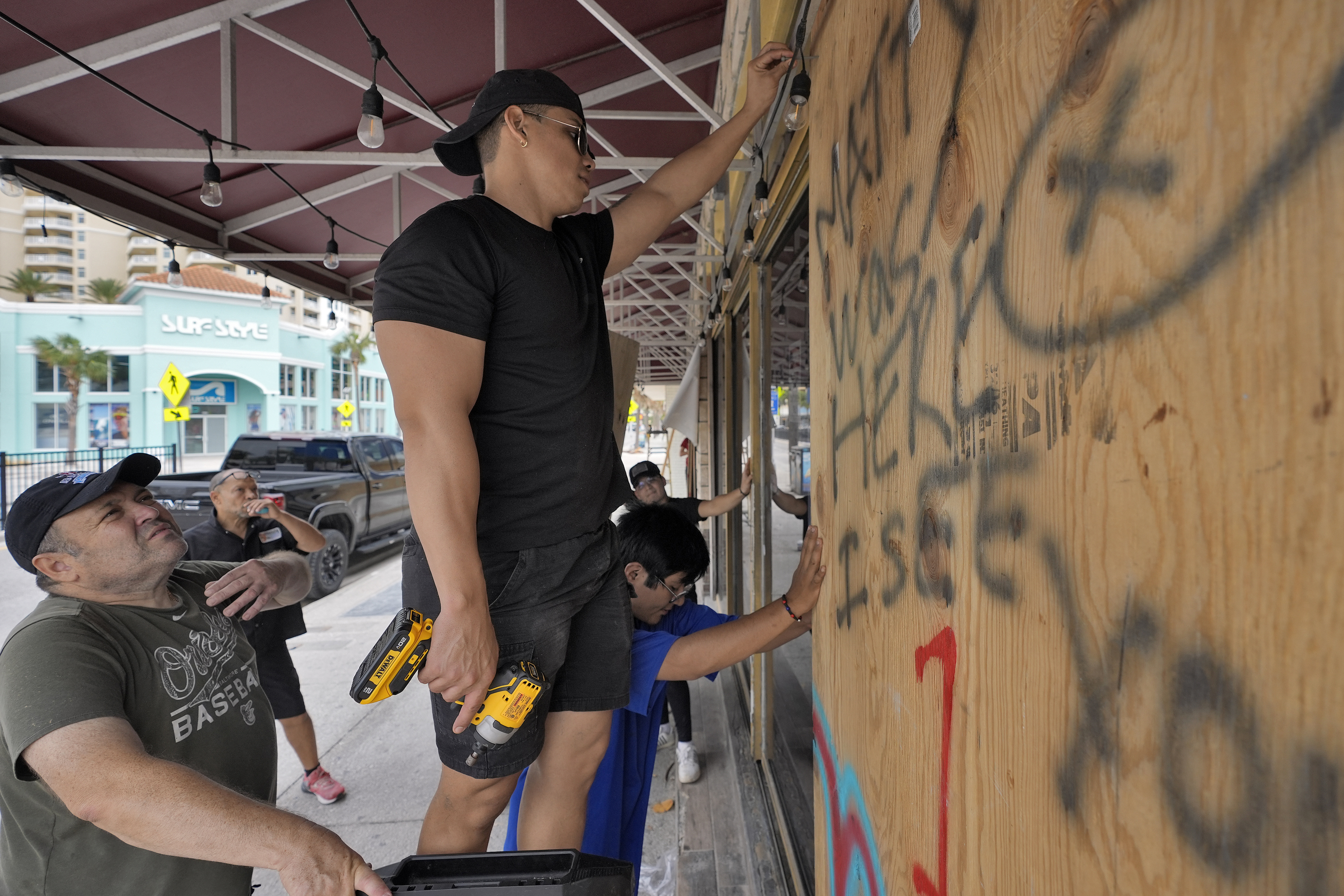 Workers outside Toucans Bar and Grill board up the restaurant Monday, Oct. 7, 2024, in Clearwater Beach, Fla., ahead of the possible arrival of Hurricane Milton. (AP Photo/Chris O'Meara)