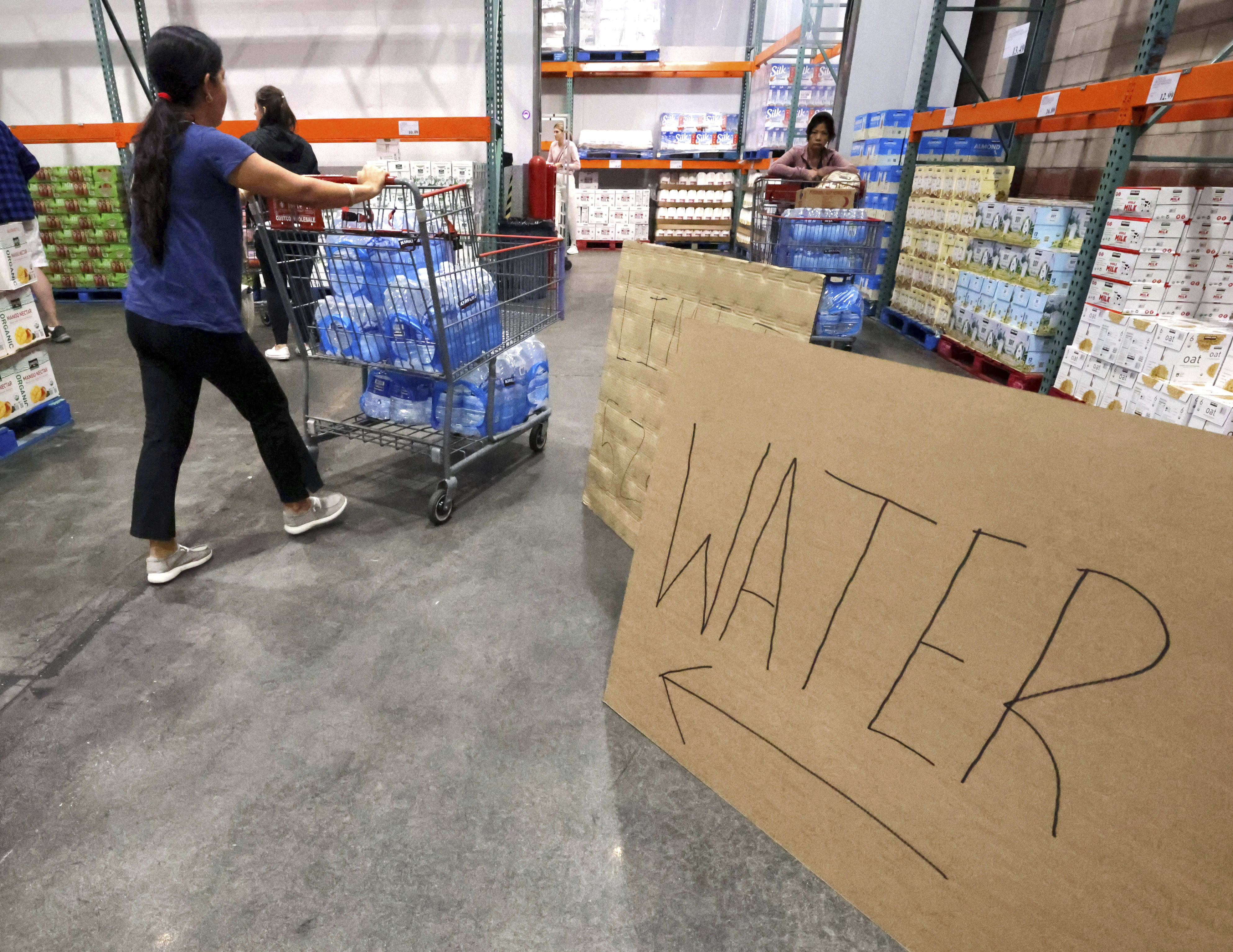 Shoppers load cases of water at the Costco at Costco, Monday, Oct. 7, 2024, in Altamonte Springs, Fla., as residents prepare for the impact of approaching Hurricane Milton. (Joe Burbank/Orlando Sentinel via AP)