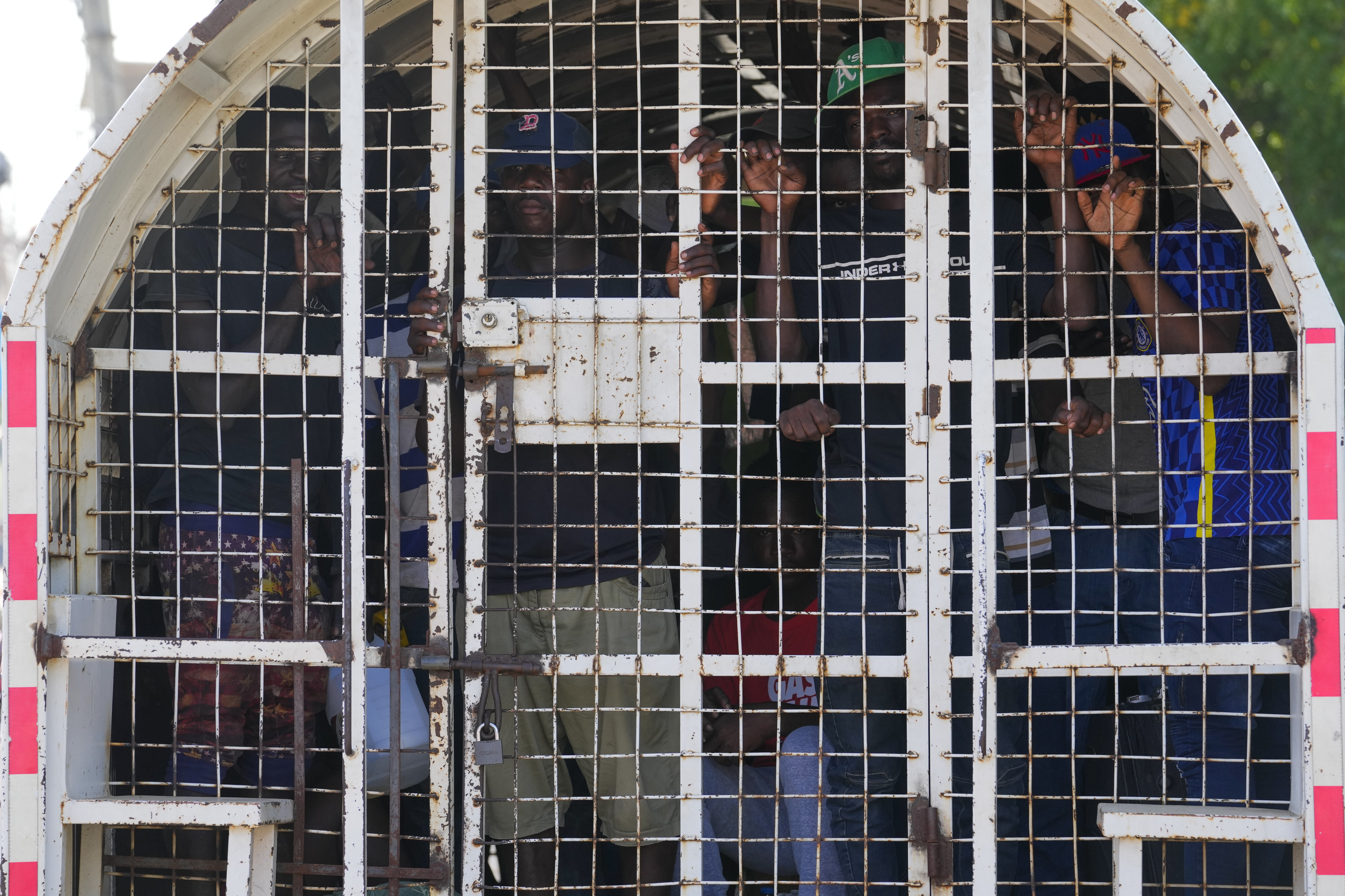 FILE - Undocumented Haitians detained by immigration officials stand inside a police vehicle, in Dajabon, Dominican Republic, May 17, 2024. (AP Photo/Matias Delacroix, File)