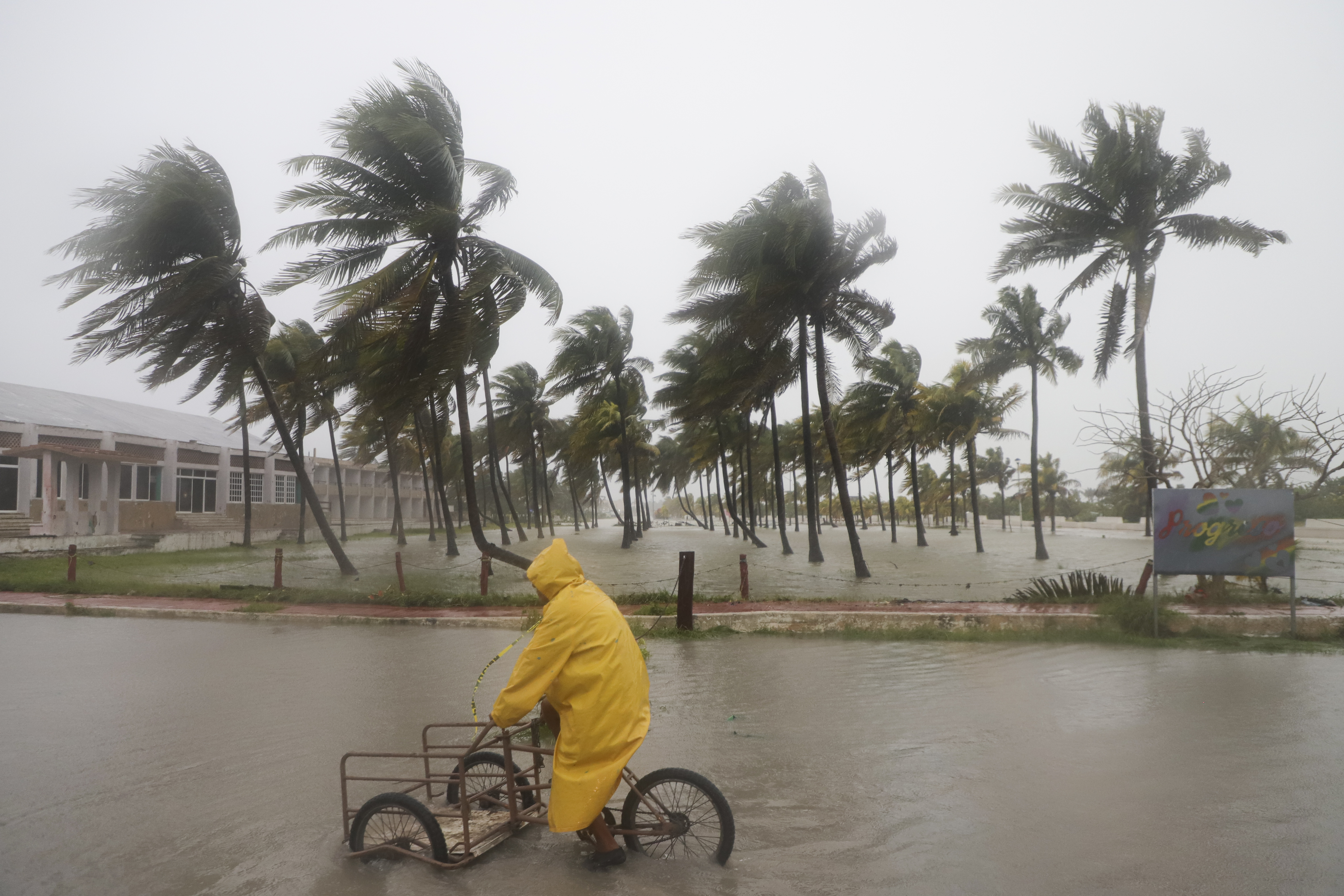 A person rides his bike through a flooded street in the rain as Hurricane Milton passes off the coast of Progreso, Yucatan state, Mexico, Tuesday, Oct. 8, 2024. (AP Photo/Martin Zetina)