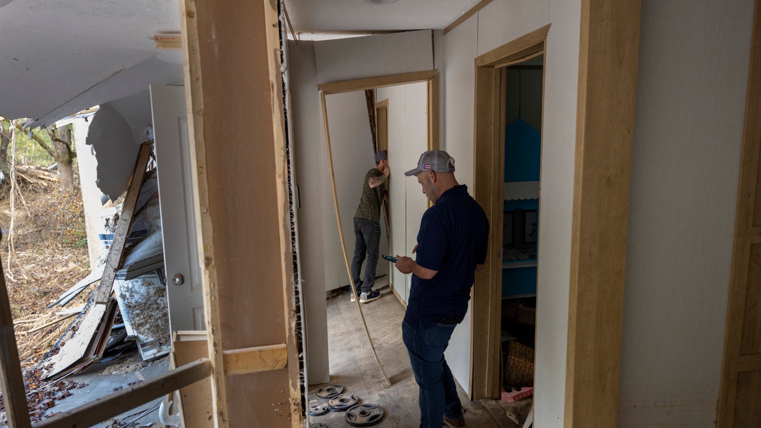 FEMA employee Jirau Alvaro works with Daniel Mancini, doing a report on the damage to his property on Sunday, Oct. 6, 2024 in rural Buncombe County, near Black Mountain, N.C. (Robert Willett/The News & Observer via AP)