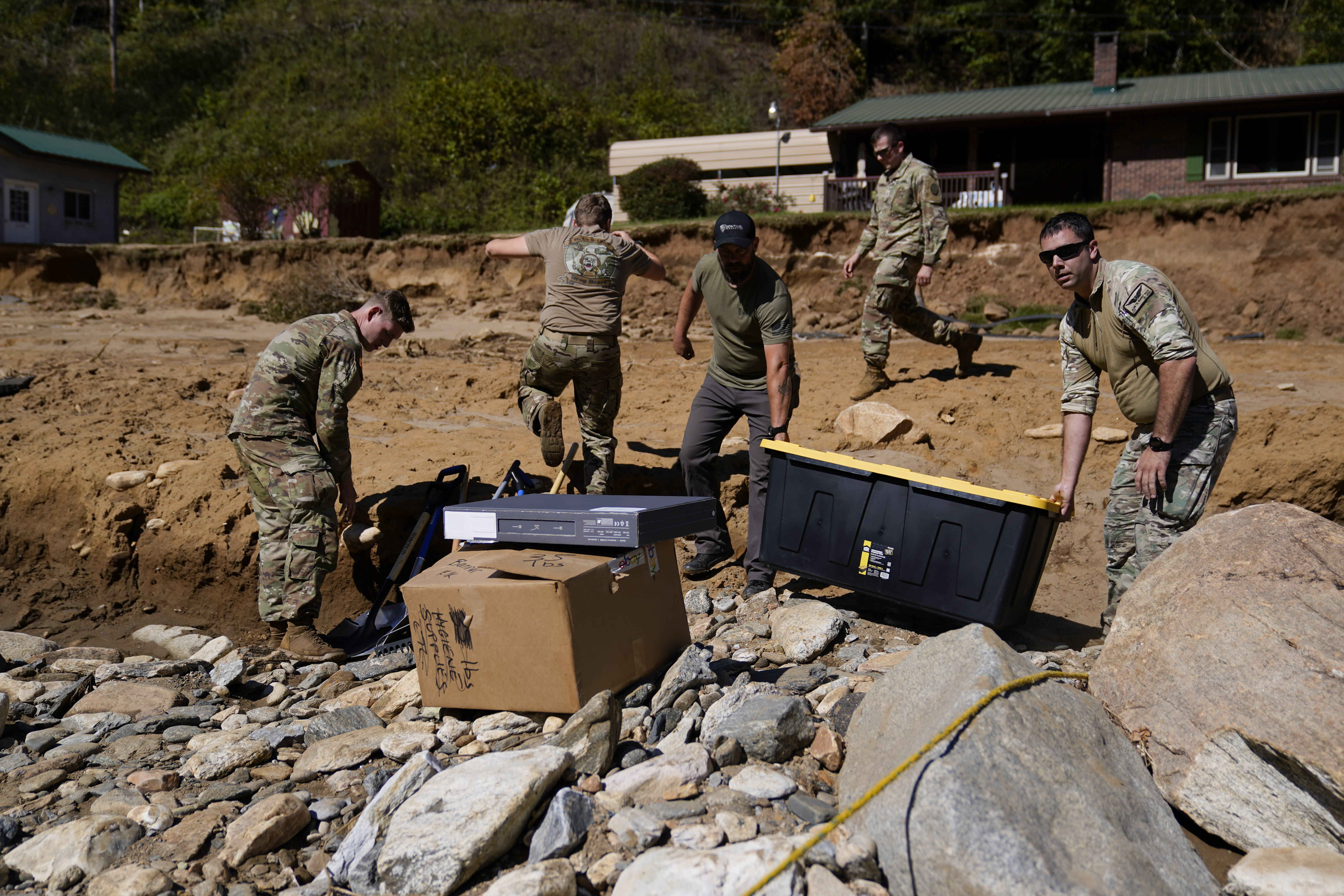 National Guard members, accompanied by a civilian volunteer, deliver supplies to residents in the aftermath of Hurricane Helene, Tuesday, Oct. 8, 2024, in Burnsville, N.C. (AP Photo/Erik Verduzco)