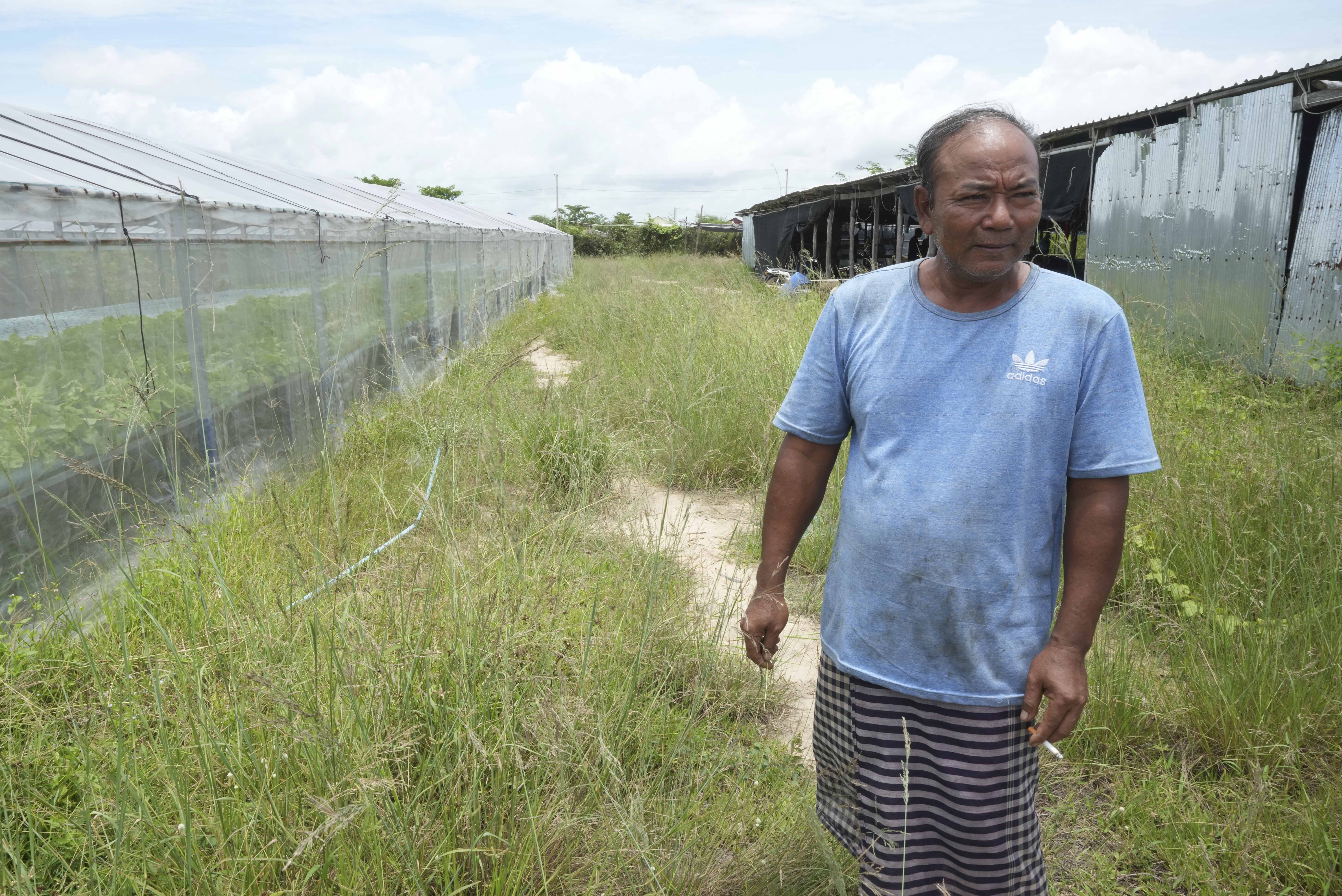 Em Phat, 53, stands in his eel farm at Tonle Sap complex, north of Phnom Penh, Cambodia, Wednesday, July 31, 2024. (AP Photo/Heng Sinith)