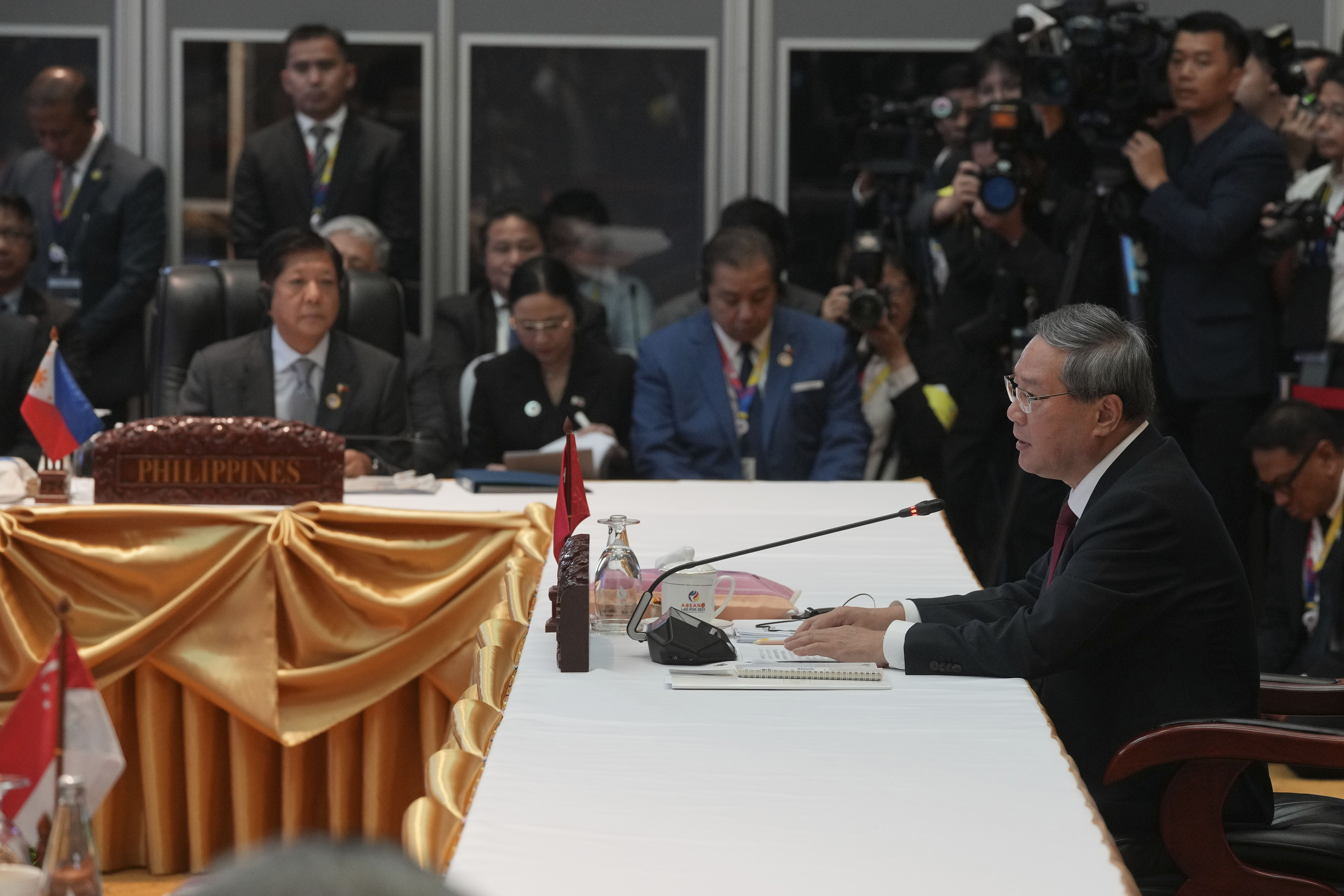 Chinese Premier Li Qiang, right, delivers his opening remarks as Philippine's President Ferdinand Marcos Jr., front left, listens during the 27th Association of Southeast Asian Nations (ASEAN)-China Summit in Vientiane, Laos, Thursday, Oct. 10, 2024. (AP Photo/Dita Alangkara)