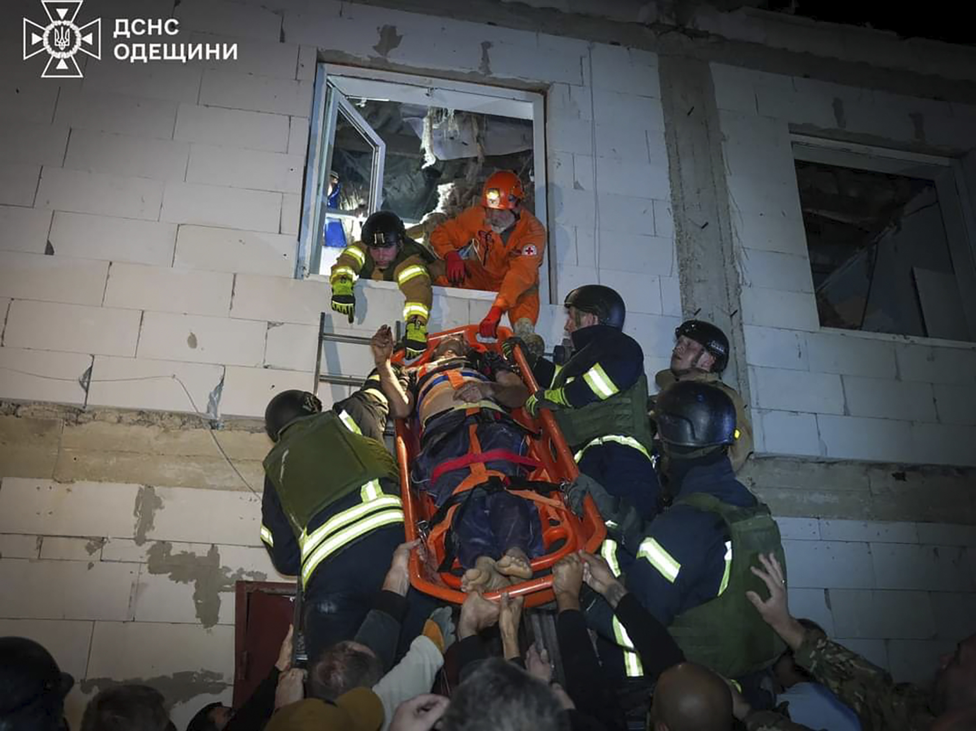 In this photo provided by the Ukrainian Emergency Service, Emergency workers carry a wounded resident after Russian missile attack in Odesa, Ukraine, late Thursday, Oct. 10, 2024. Four Russian missile and drone attacks on the Odesa region this week have killed 14 people and wounded around 20, according to local officials. (Ukrainian Emergency Service via AP)