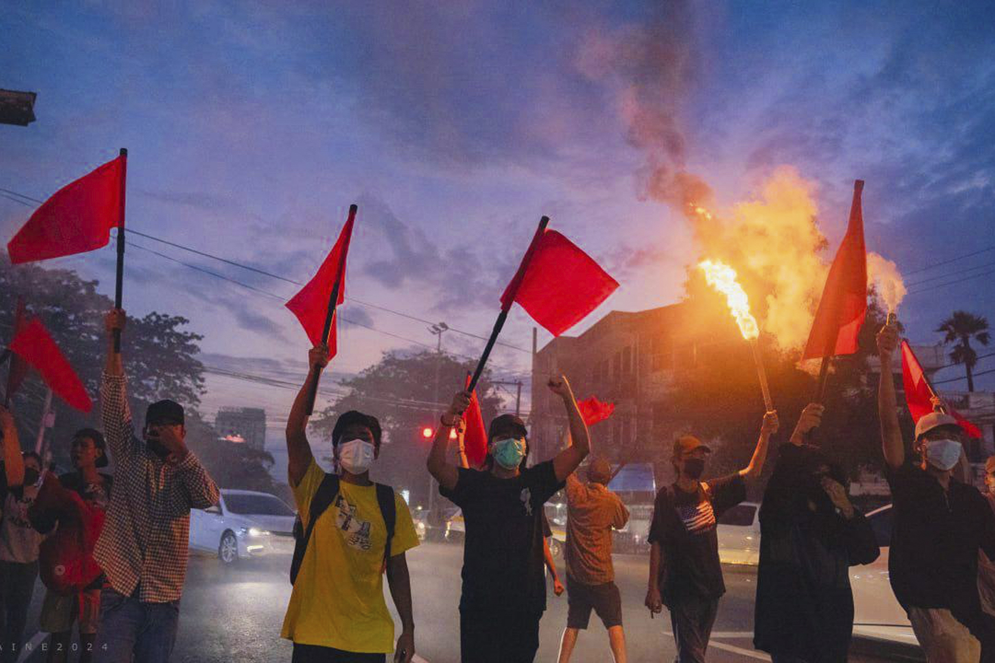 Pro-democracy protesters hold torches and flags during a flash mob rally to protest against Myanmar's military-government in Yangon, Myanmar on Sept.19, 2024. (Anti-Junta Alliance Yangon via AP)