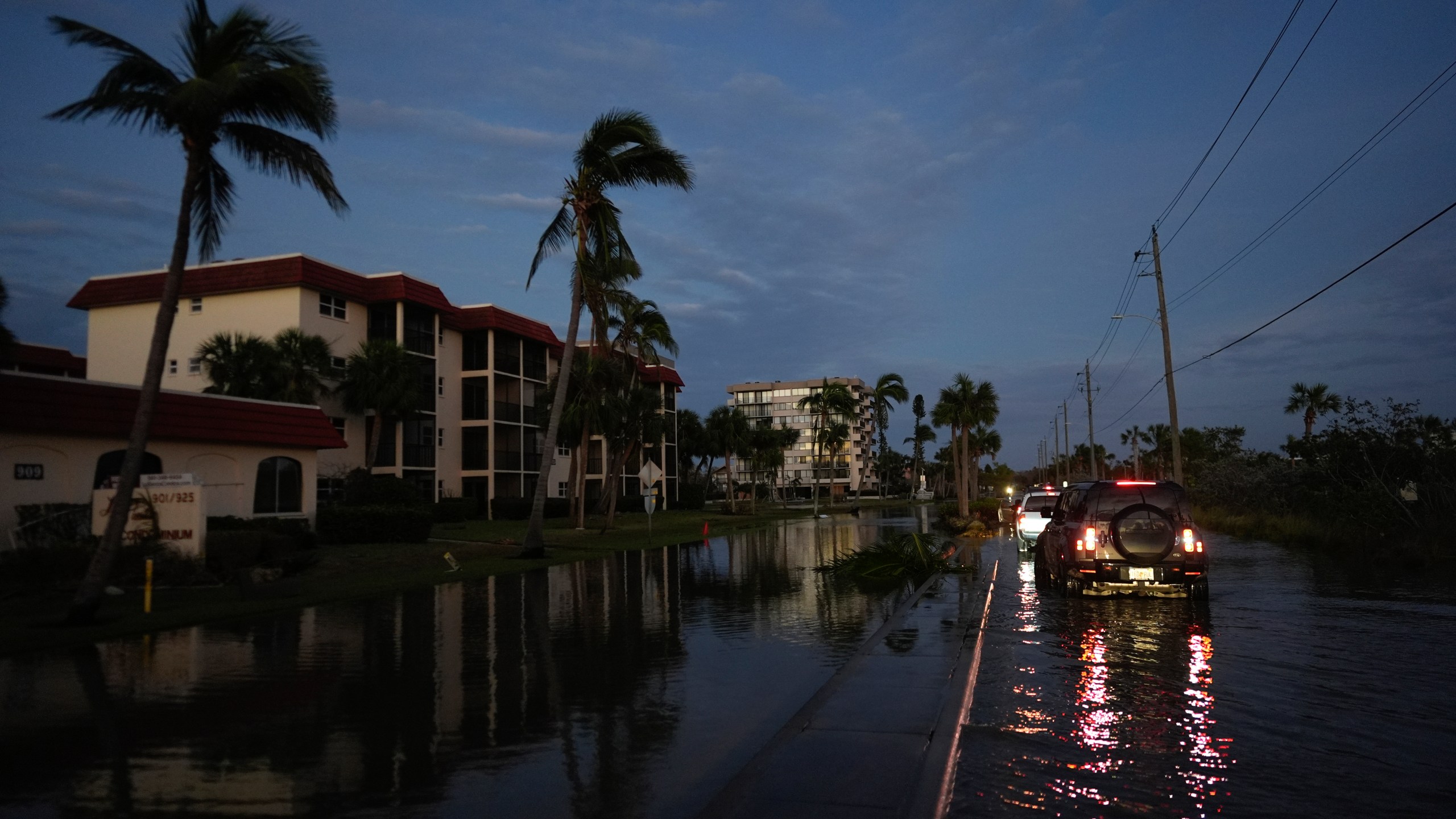 A car backs up after encountering deeper water on a flooded street in Siesta Key, Fla., following the passage of Hurricane Milton, Thursday, Oct. 10, 2024. (AP Photo/Rebecca Blackwell)