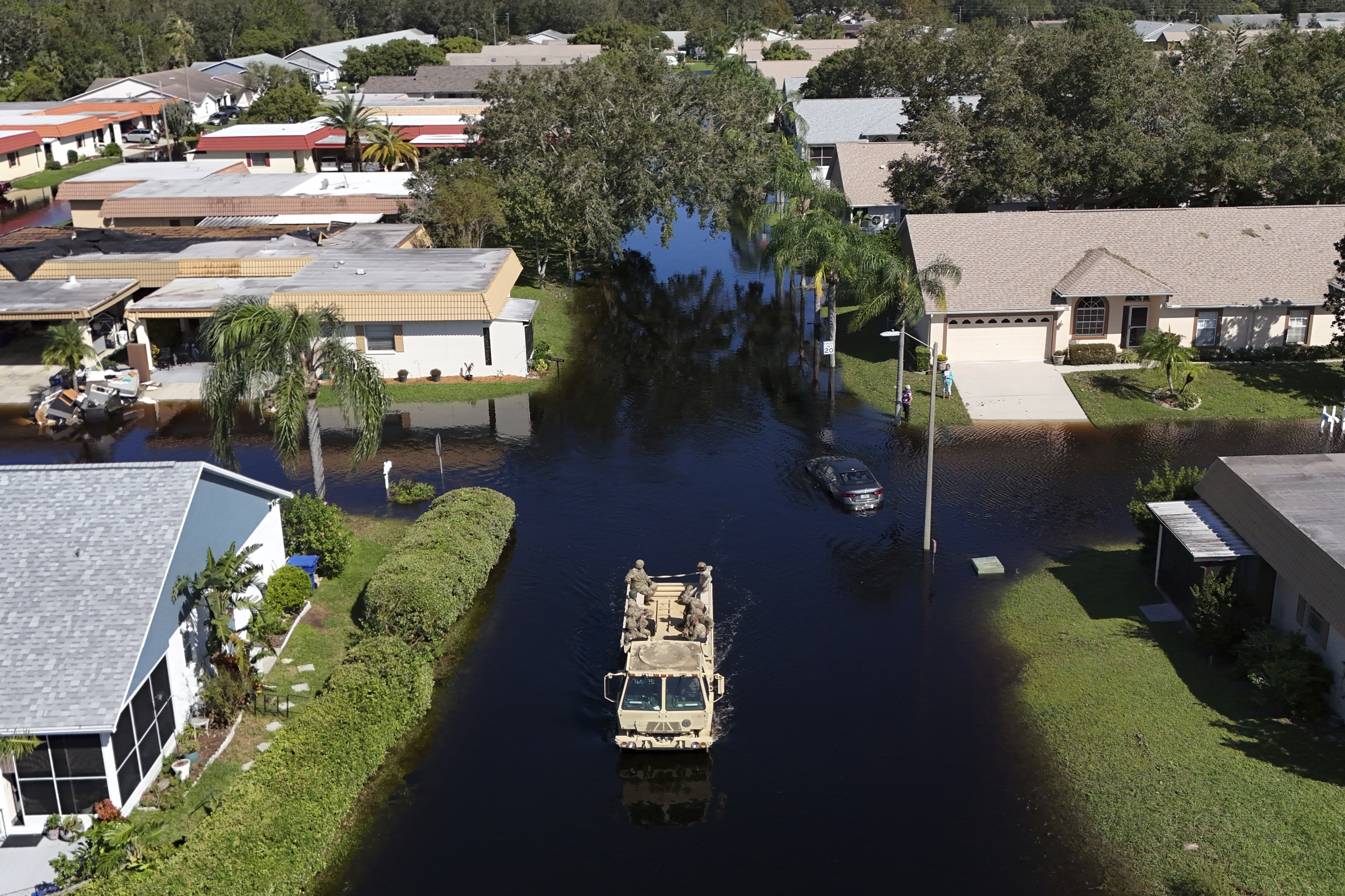 A truck from the Florida National Guard goes out to help residents trapped in their homes as waters rise after Hurricane Milton caused the Anclote River to flood, Friday, Oct. 12, 2024, in New Port Richey, Fla. (AP Photo/Mike Carlson)