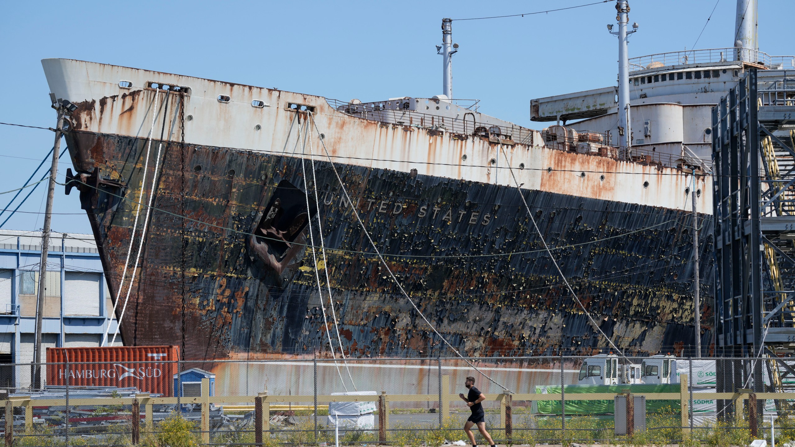 FILE - A person runs past the S.S. United States moored on the Delaware River in Philadelphia, Sept. 4, 2024. (AP Photo/Matt Rourke, File)