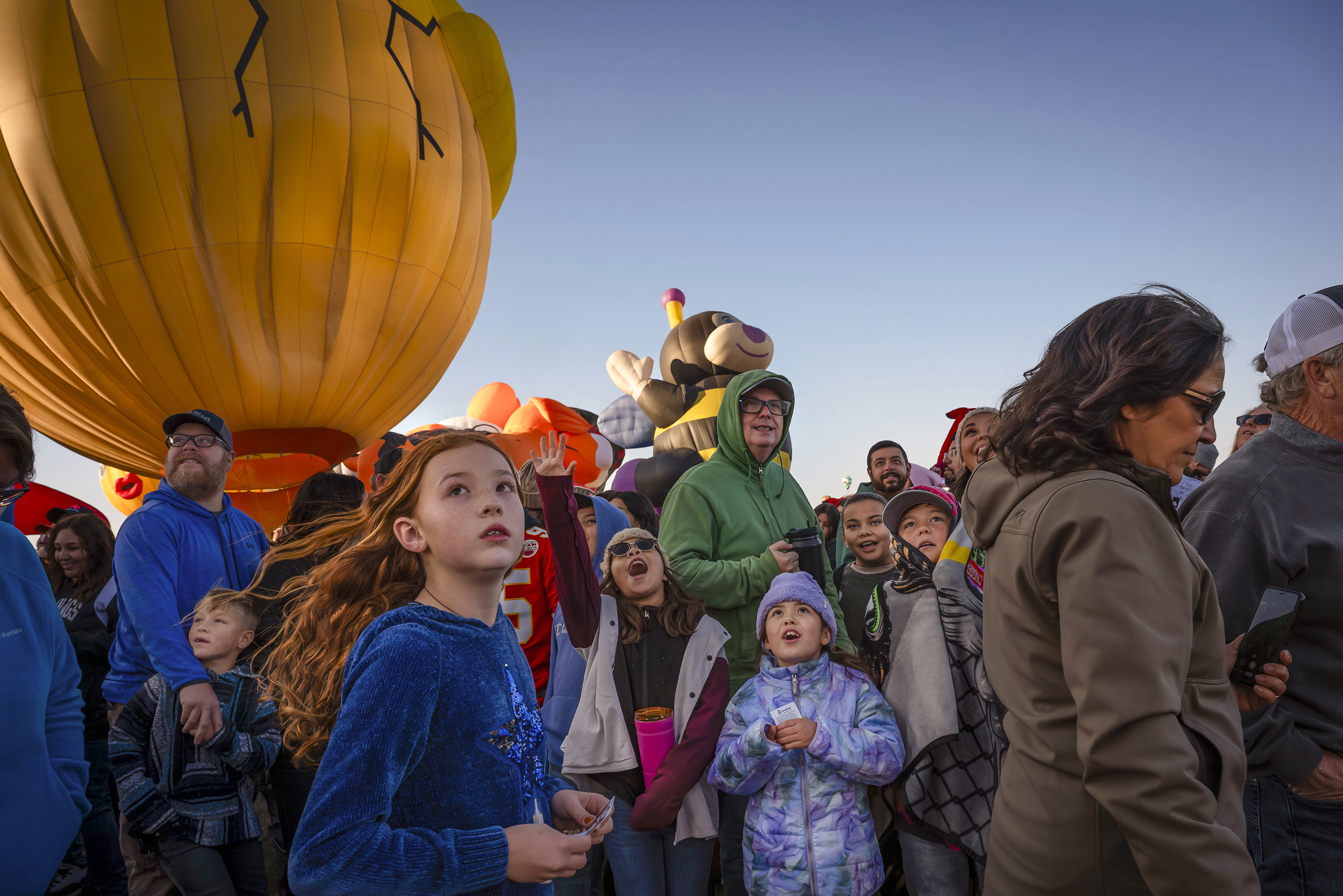 Abiyah Sailors, 9, center left, and Brooklan Parker, 8, center right, react to the Zozobra special shape balloon during the Albuquerque International Balloon Fiesta's Special Shape Rodeo and balloon launch at Balloon Fiesta Park in Albuquerque, N.M., on Thursday, Oct. 10, 2024. (Chancey Bush/The Albuquerque Journal via AP)