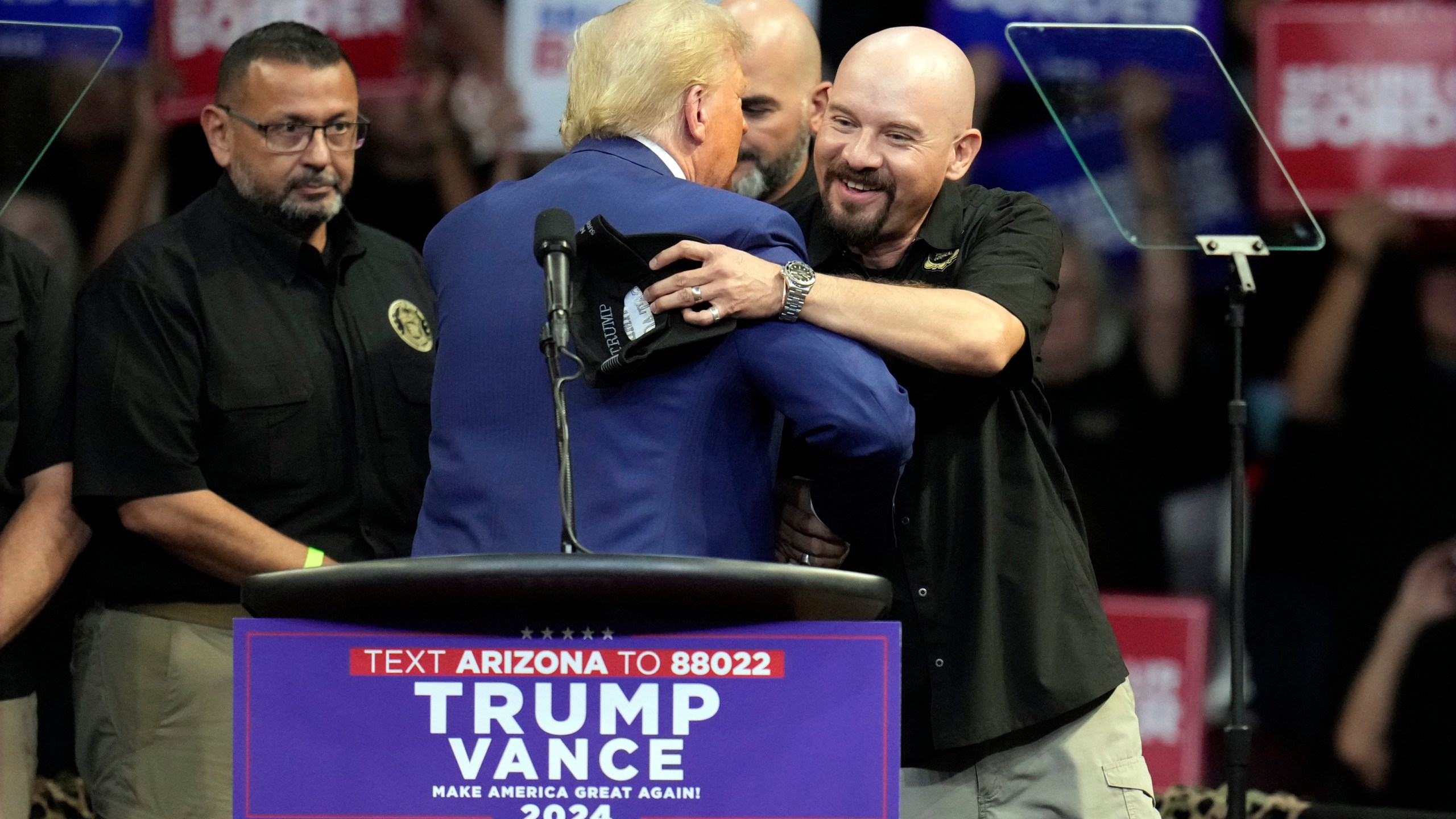 Art del Cueto, vice president of the National Border Patrol Council, embraces Republican presidential nominee former President Donald Trump at a campaign rally at the Findlay Toyota Arena Sunday, Oct. 13, 2024, in Prescott Valley, Ariz. (AP Photo/Ross D. Franklin)