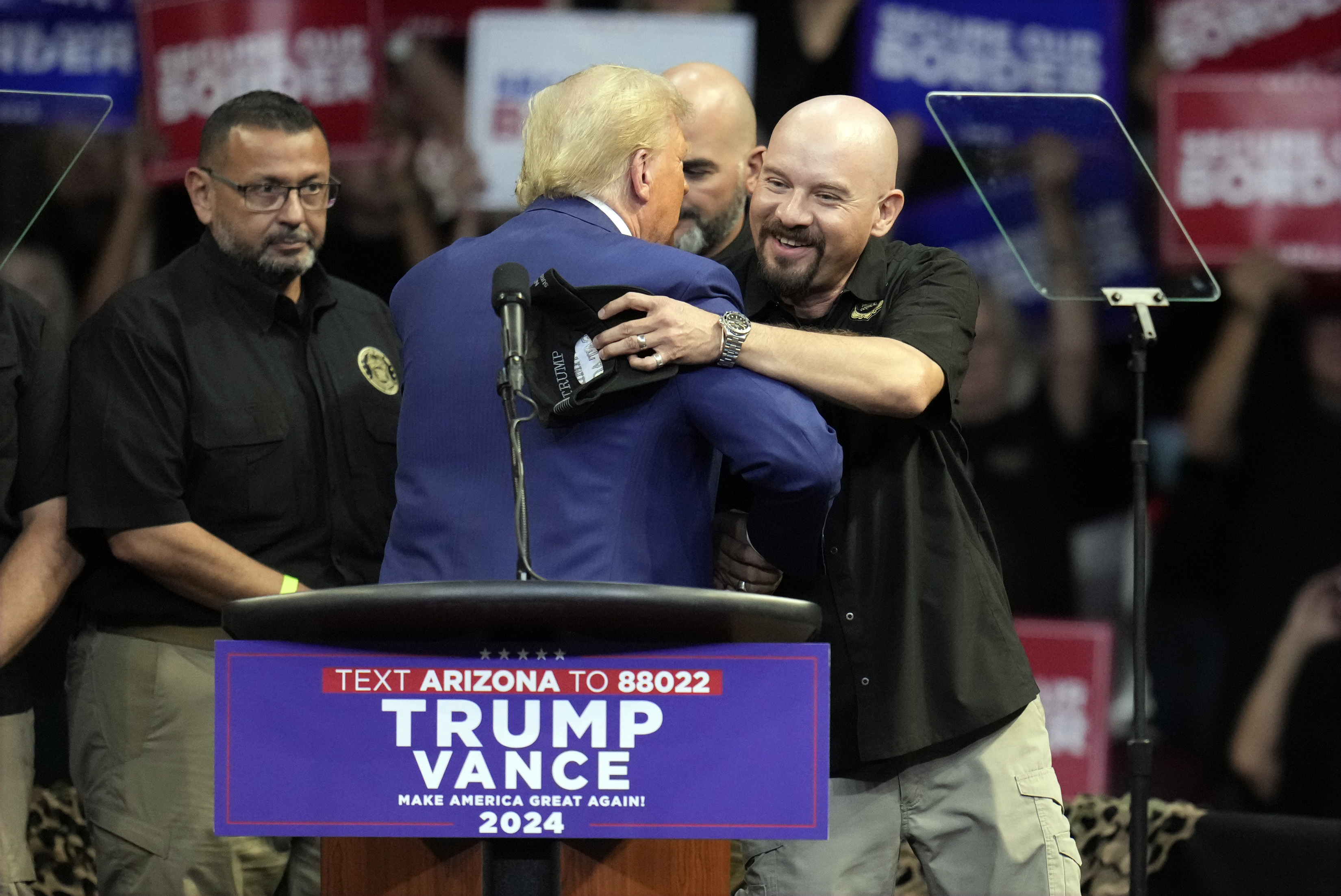 Art del Cueto, vice president of the National Border Patrol Council, embraces Republican presidential nominee former President Donald Trump at a campaign rally at the Findlay Toyota Arena Sunday, Oct. 13, 2024, in Prescott Valley, Ariz. (AP Photo/Ross D. Franklin)