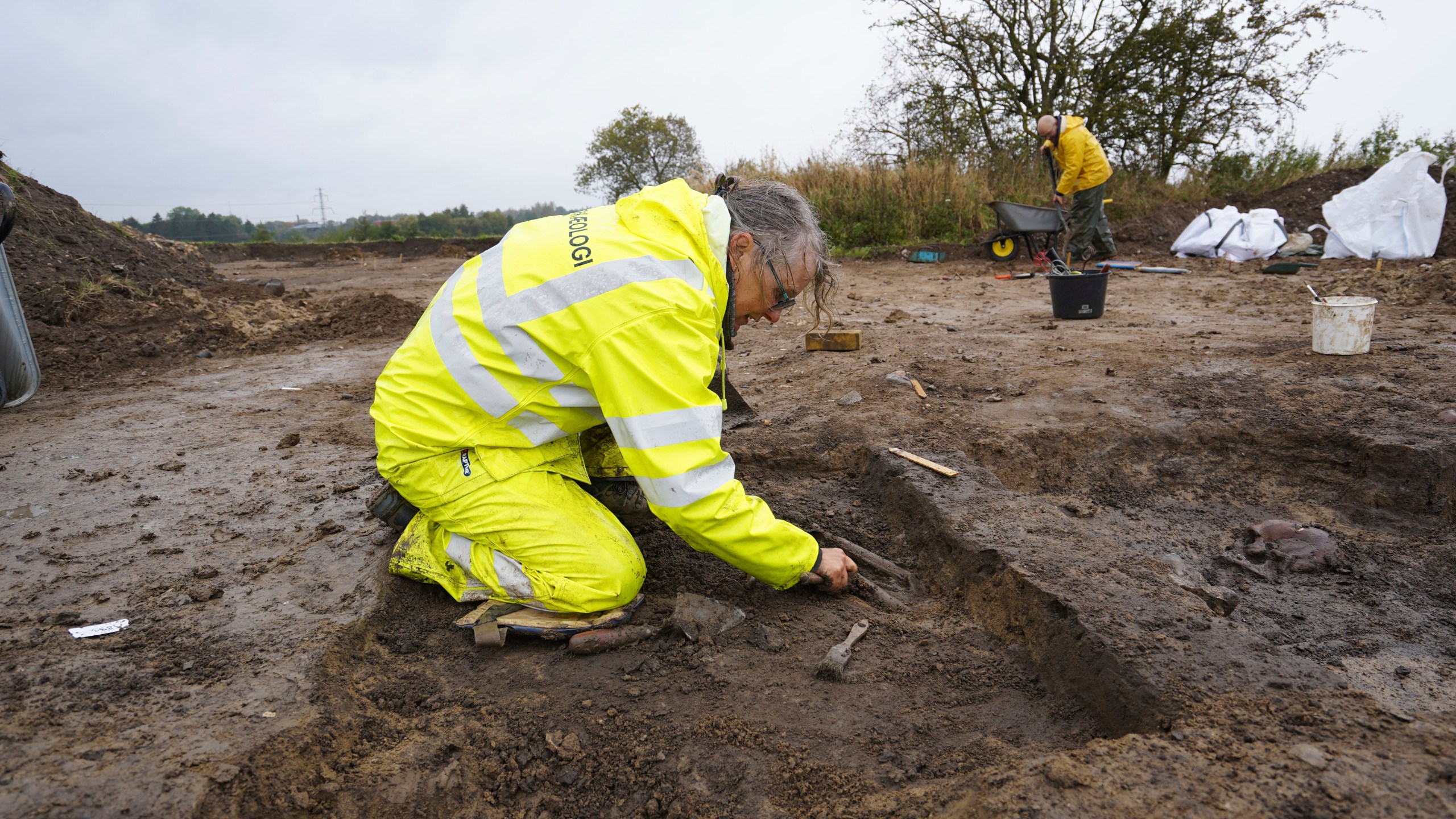 Kirsten Prangsgaard, archaeologist at Museum Odense, works at an excavation site of a 10th century Viking burial ground in Aasum, Denmark, Monday, Oct. 7, 2024. (AP Photo/James Brooks)