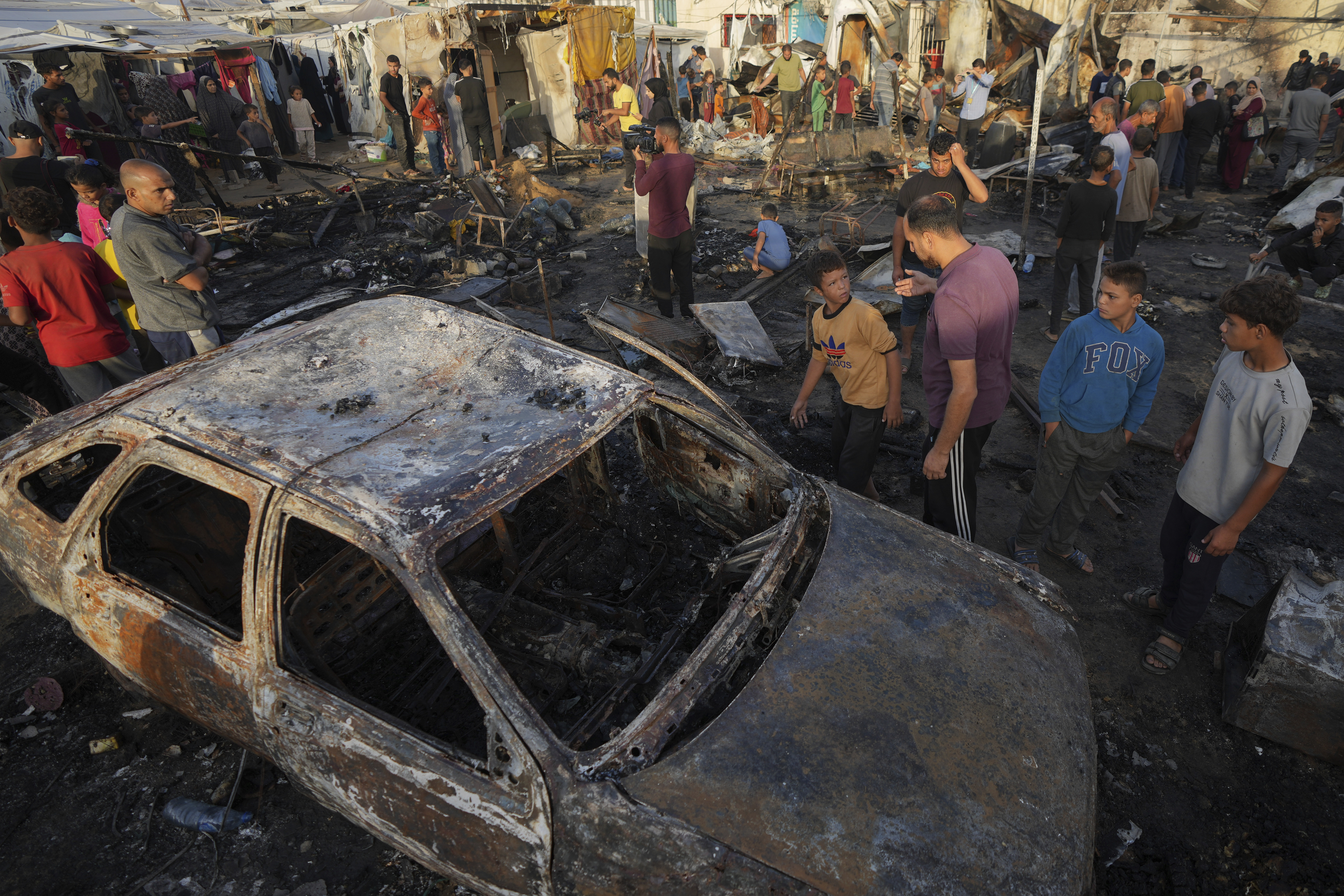 Palestinians look at the damage after an Israeli strike hit a tent area in the courtyard of Al Aqsa Martyrs hospital in Deir al Balah, Gaza Strip, Monday, Oct. 14, 2024. (AP Photo/Abdel Kareem Hana)