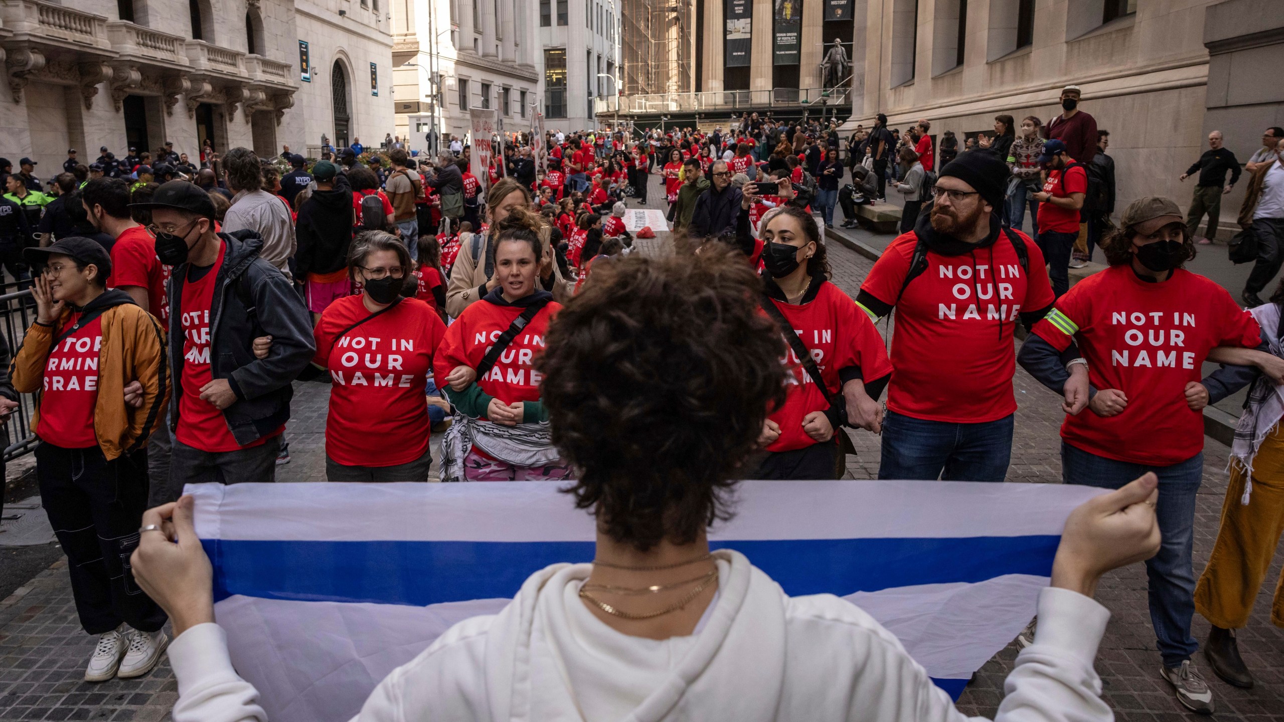 A pro-Israel protester holds an Israeli flag as demonstrators protest Israel's war against Hamas outside the New York Stock Exchange, Monday, Oct. 14, 2024, in New York. (AP Photo/Yuki Iwamura)