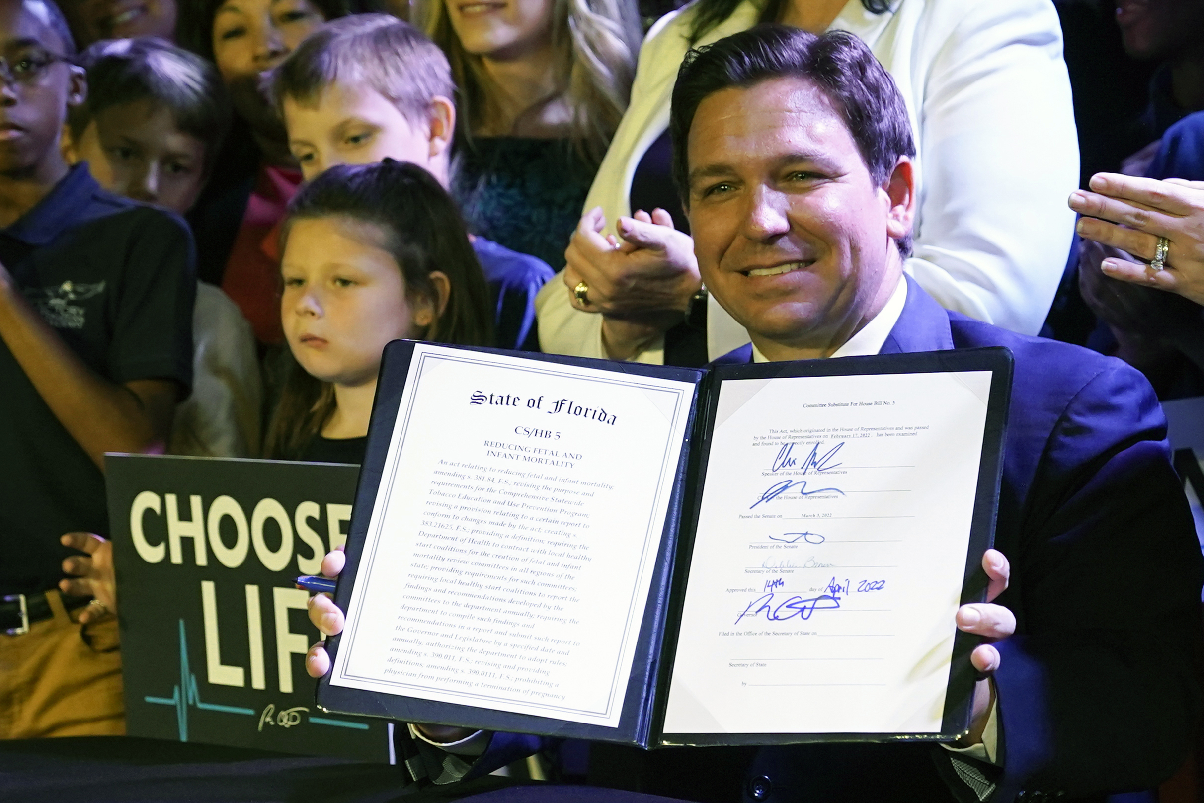 FILE - Florida Gov. Ron DeSantis holds up a 15-week abortion ban law after signing it on April 14, 2022, in Kissimmee, Fla. (AP Photo/John Raoux, File)