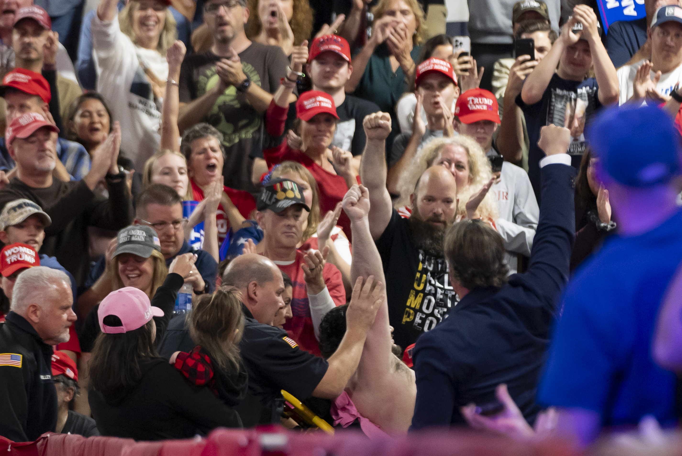 A man raises his fist as he taken away on a stretcher as Republican presidential nominee former President Donald Trump speaks at a campaign town hall at the Greater Philadelphia Expo Center & Fairgrounds, Monday, Oct. 14, 2024, in Oaks, Pa. (AP Photo/Alex Brandon)