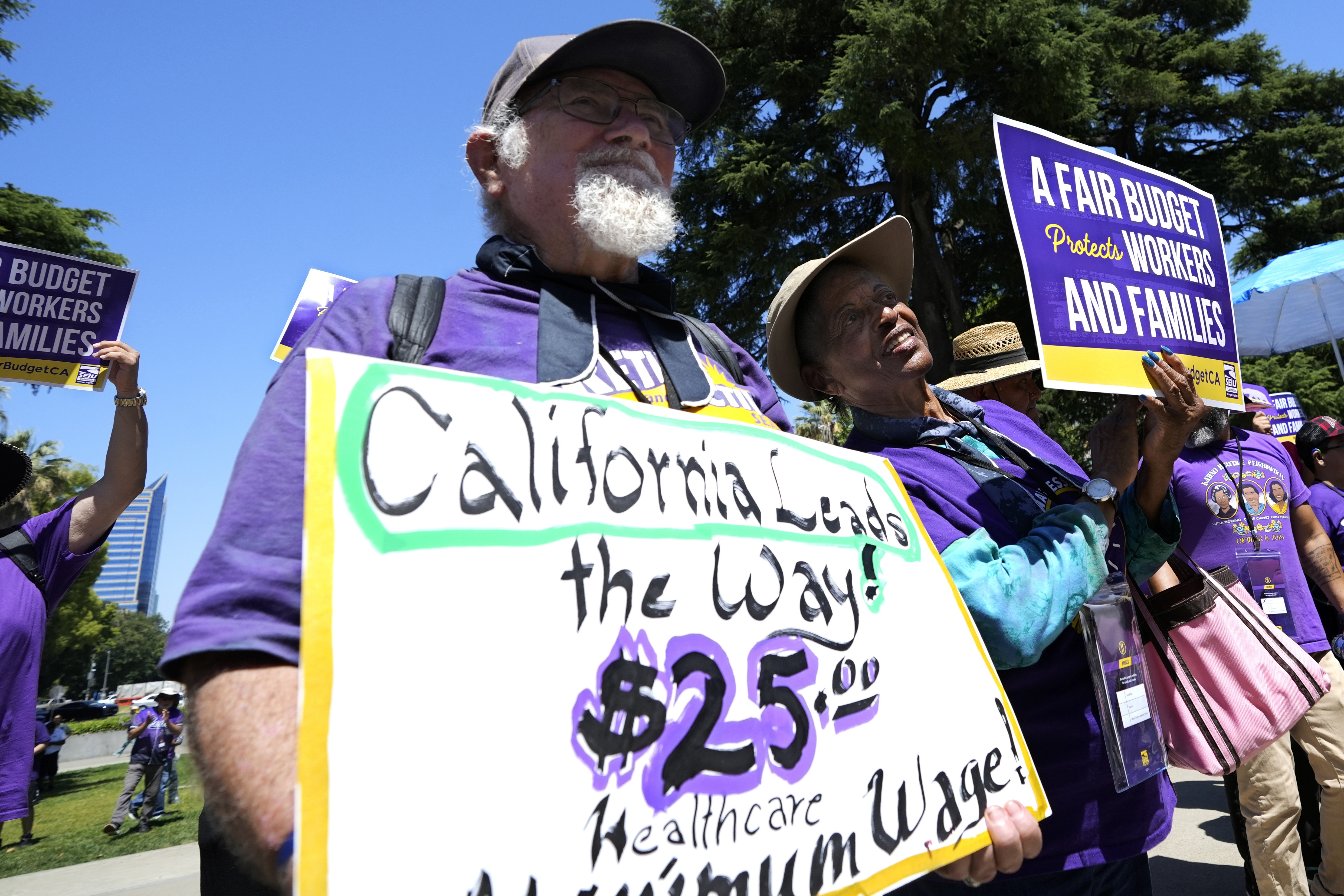 FILE - Retirees Ron Martin, left, and Willie Mae Hampton, right, join other supporters of the Service Employees International Union at a rally against proposed budget cuts to state provided social safety net programs, in Sacramento, Calif., Tuesday, June 11, 2024. (AP Photo/Rich Pedroncelli, File)