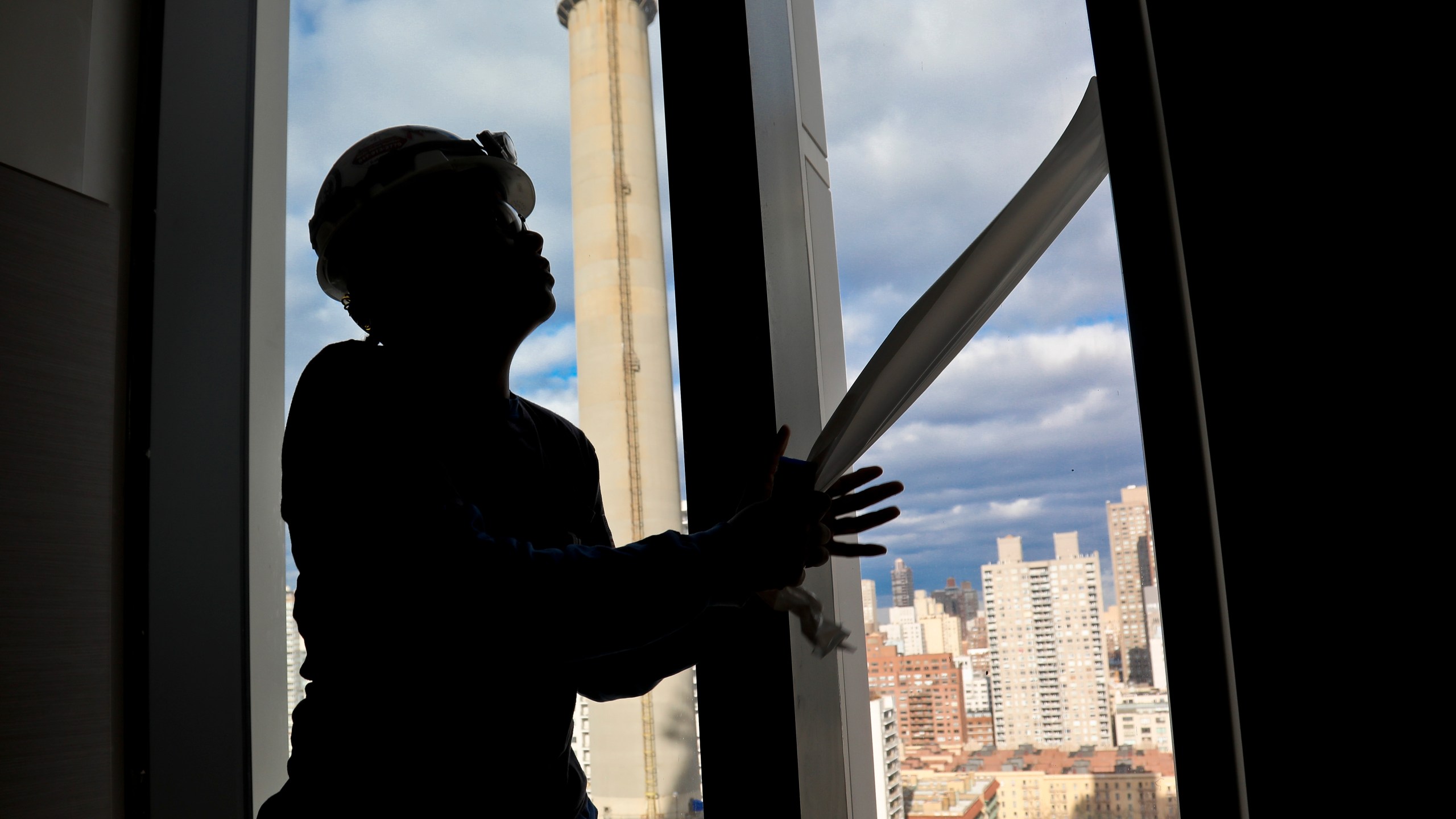 FILE - Construction laborer Myrtle Wilson prepares for a the installation of windows on a building on Jan. 9, 2019 in New York. (AP Photo/Bebeto Matthews, File)