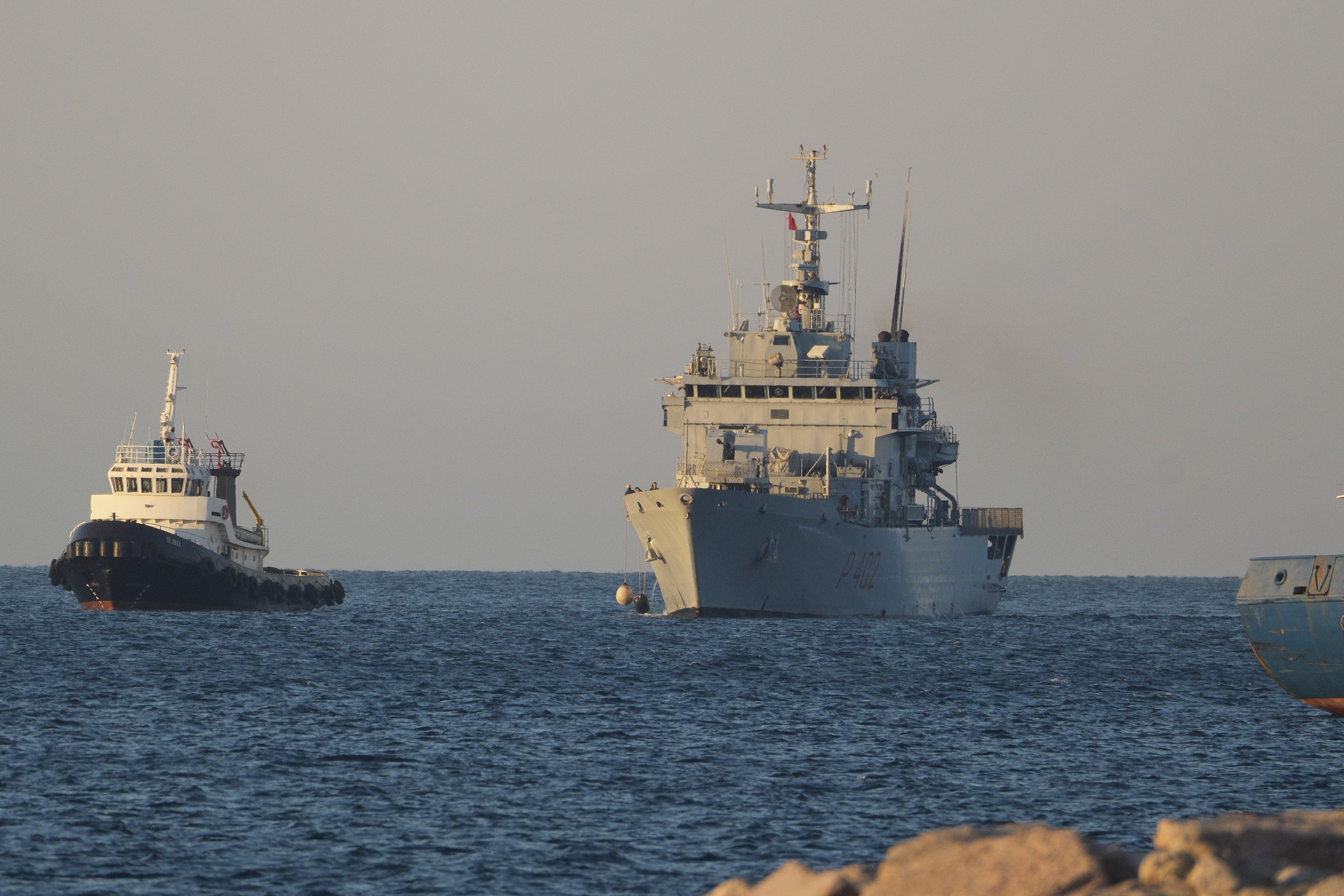 The Italian navy ship Libra, right, arrives at the port of Shengjin northwestern Albania Wednesday, Oct. 16, 2024, carrying the first group of migrants who were intercepted in international waters. (AP Photo/Vlasov Sulaj)