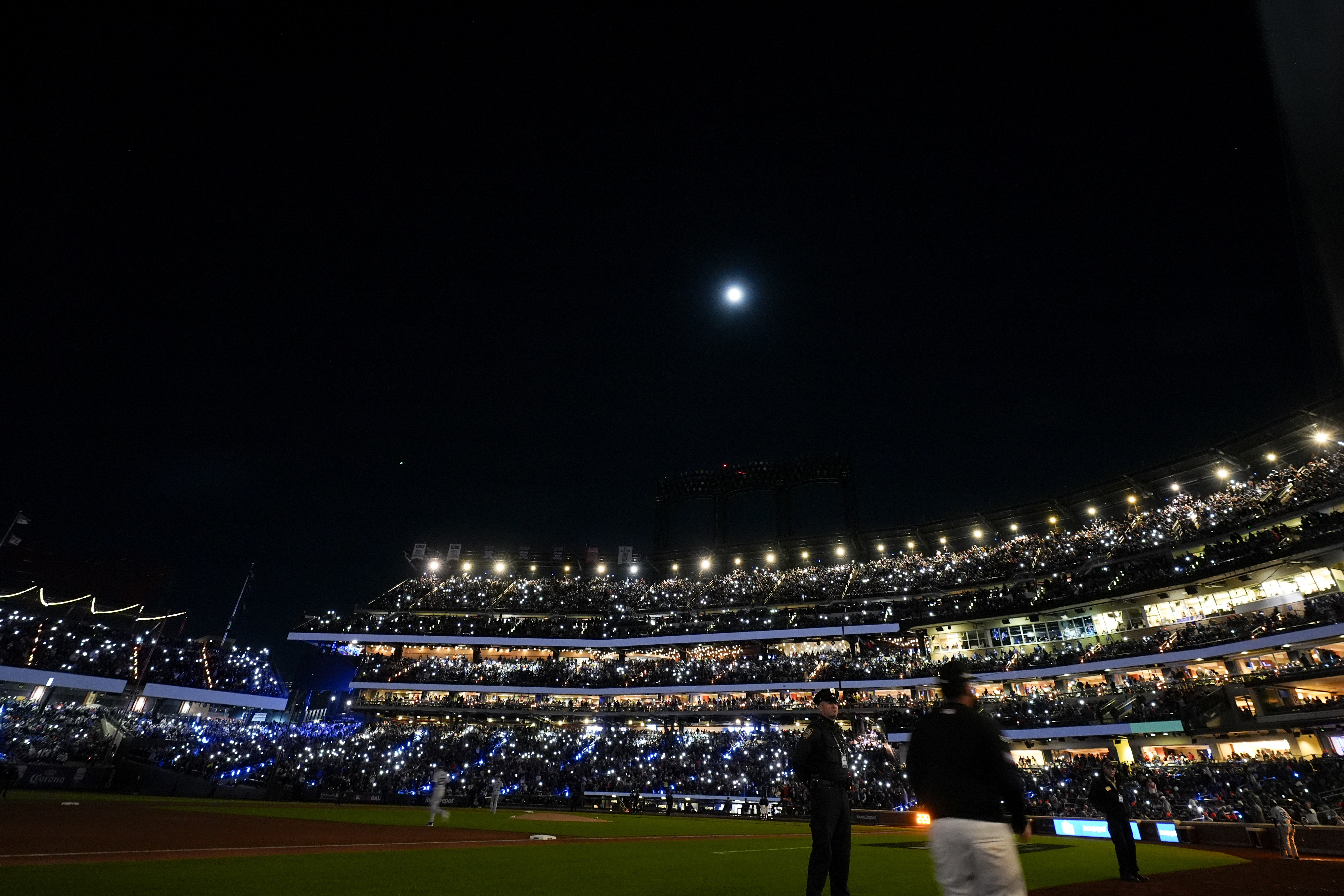 Fans light up the stadium during the third inning in Game 3 of a baseball NL Championship Series between the Los Angeles Dodgers and the New York Mets, Wednesday, Oct. 16, 2024, in New York. (AP Photo/Frank Franklin II)