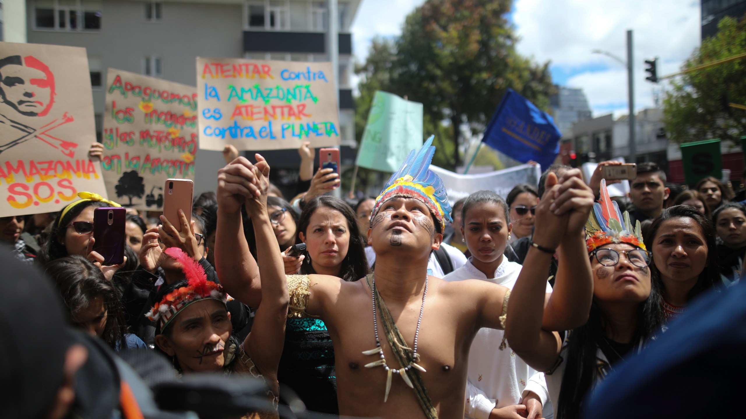 FILE - Indigenous demonstrators join a protest outside Brazilian embassy to call on Brazil's President Jair Bolsonaro to act to protect the Amazon rainforest, in Bogota, Colombia, Aug. 23, 2019. (AP Photo/Ivan Valencia, File)